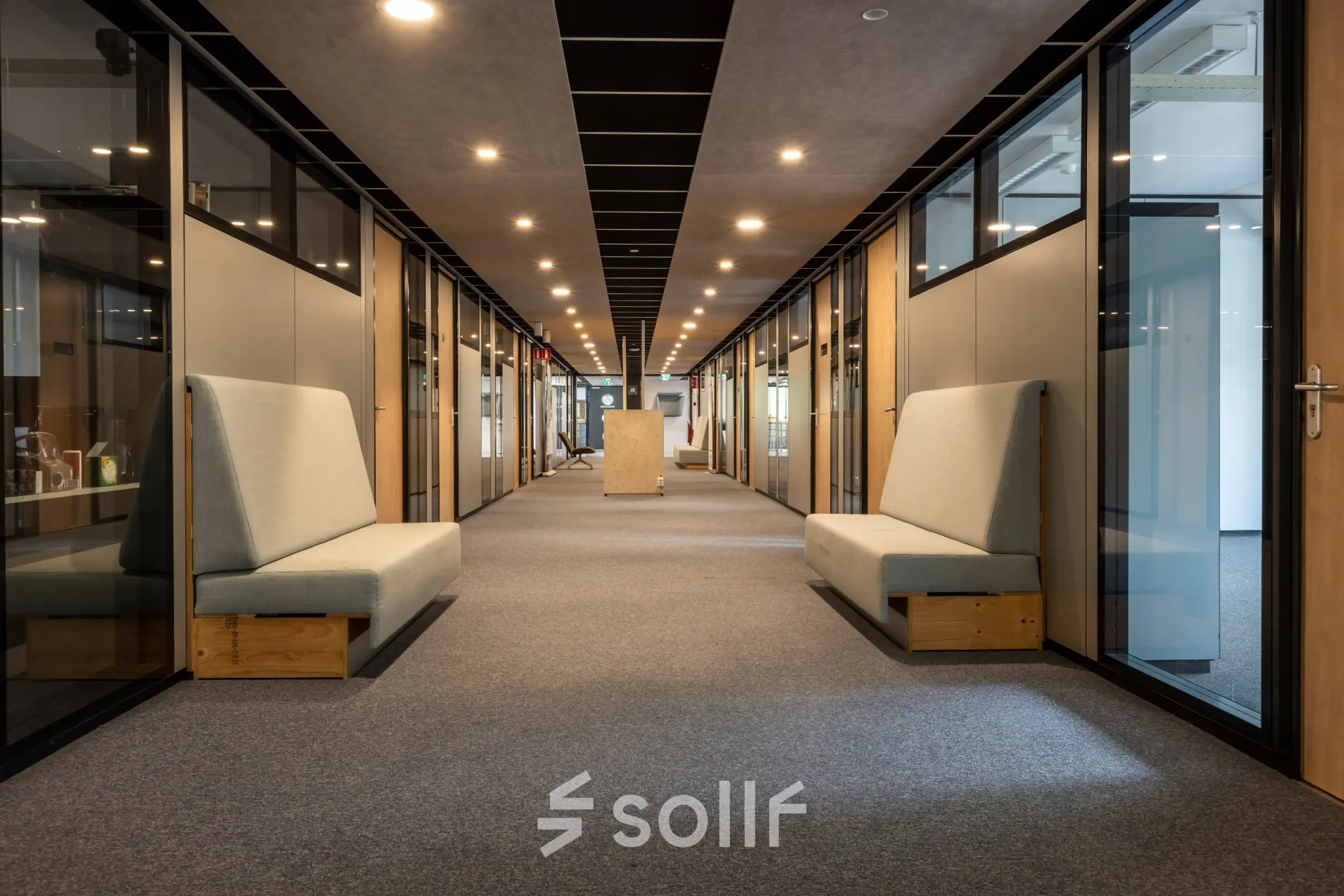 Spacious office hallway at Delftechpark 9, Delft, showcasing modern seating and lighting, ideal for those looking to rent office space. The office to rent offers a sleek, functional design.