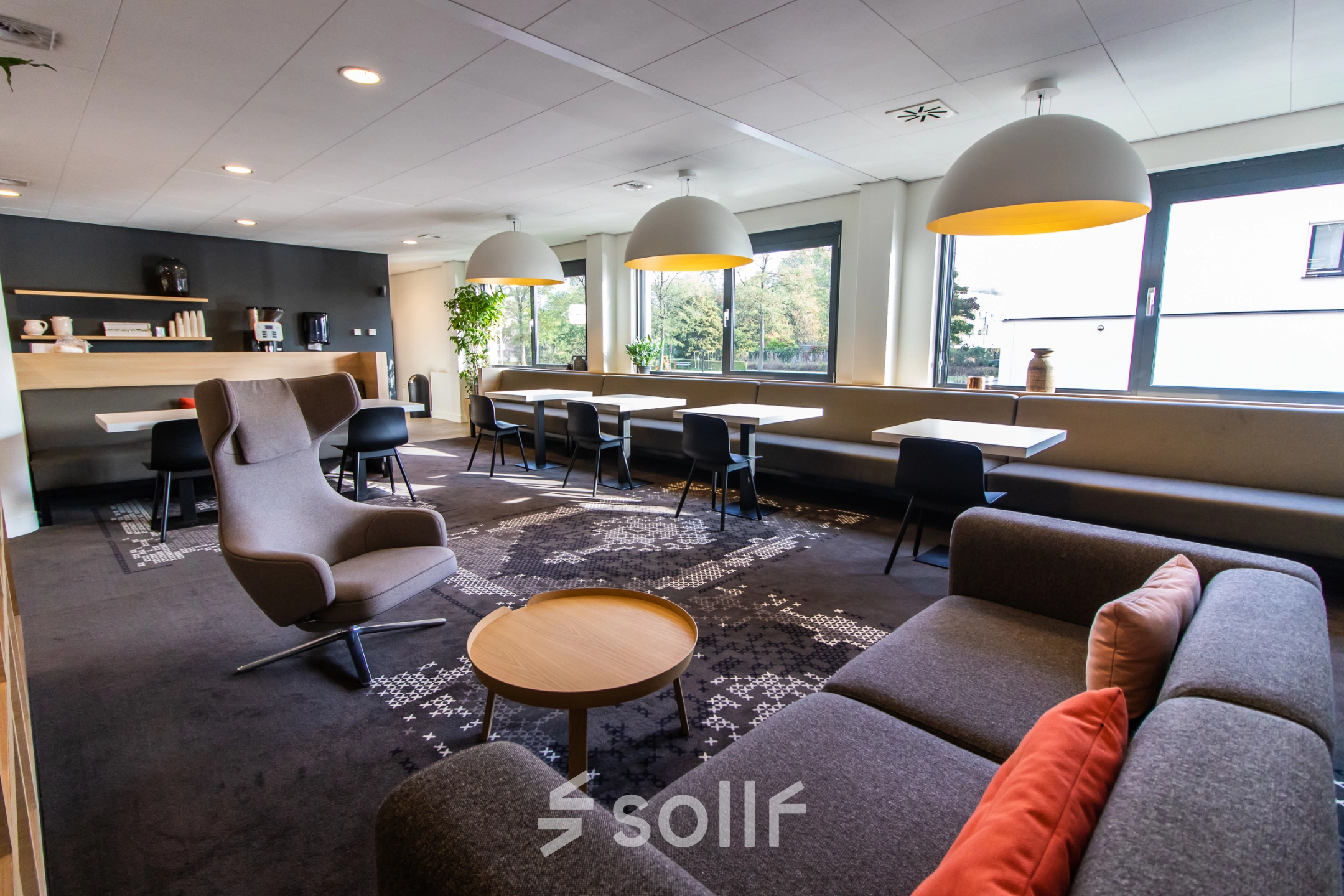 Bright and inviting office space for rent at Marshalllaan 2, Delft, featuring modern furniture with comfortable seating and ample natural light from large windows.