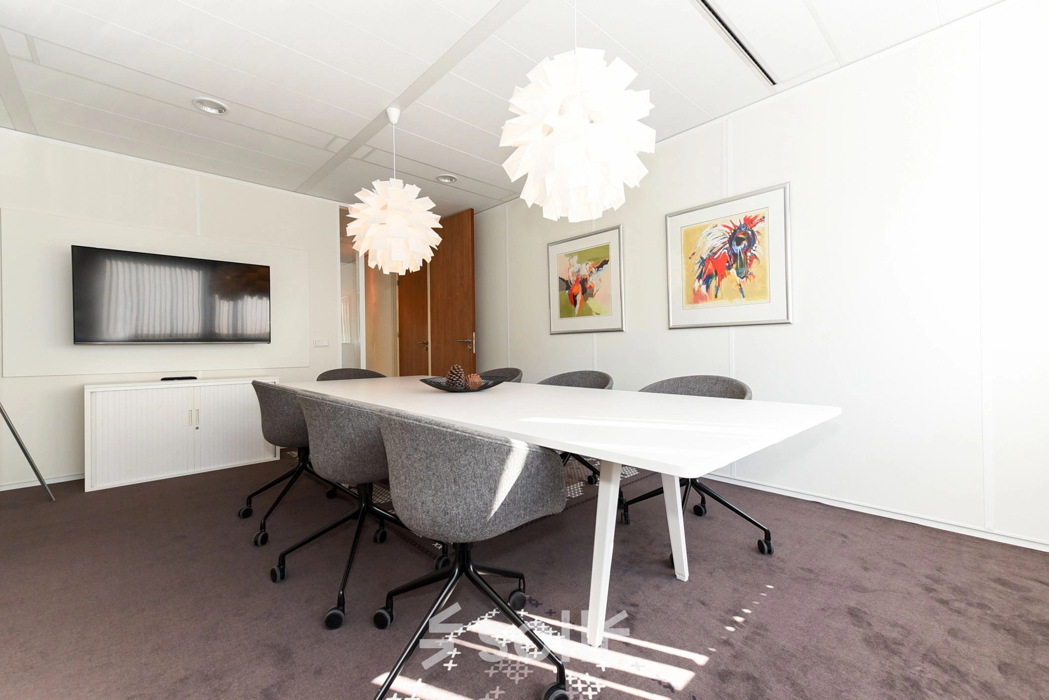 Bright office space at Marshalllaan 2, Delft with modern decor, featuring a long table, chairs, and decorative lighting, ideal for office space rental.