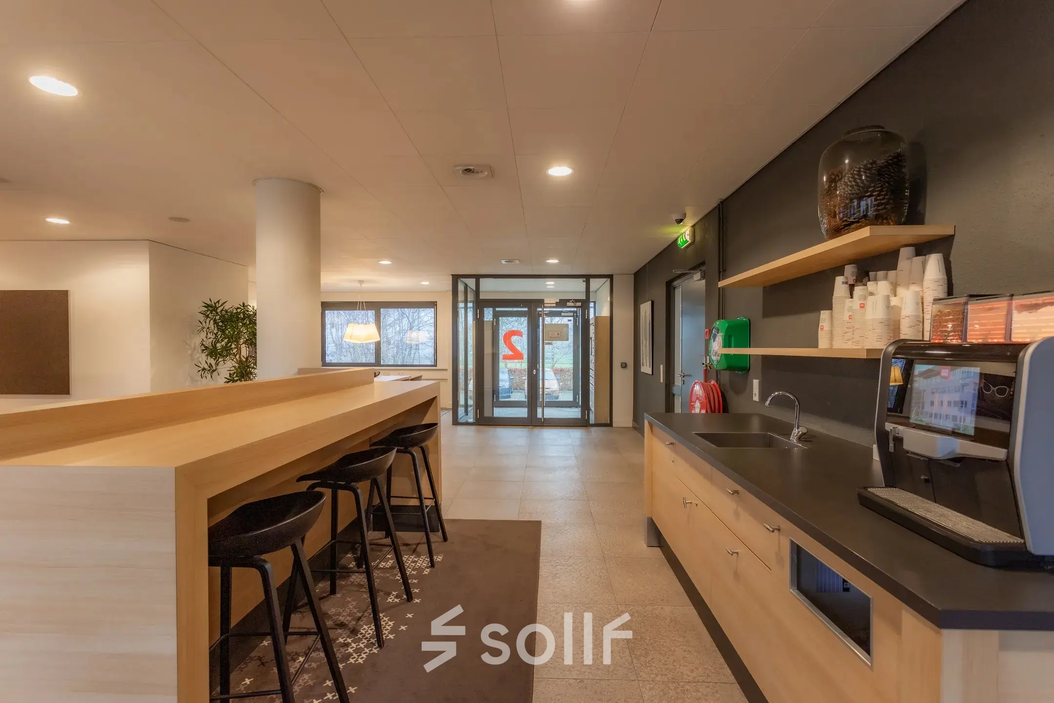 Modern interior view of office space for rent at Marshalllaan 2, Delft, featuring a kitchenette with seating area and ample natural light.