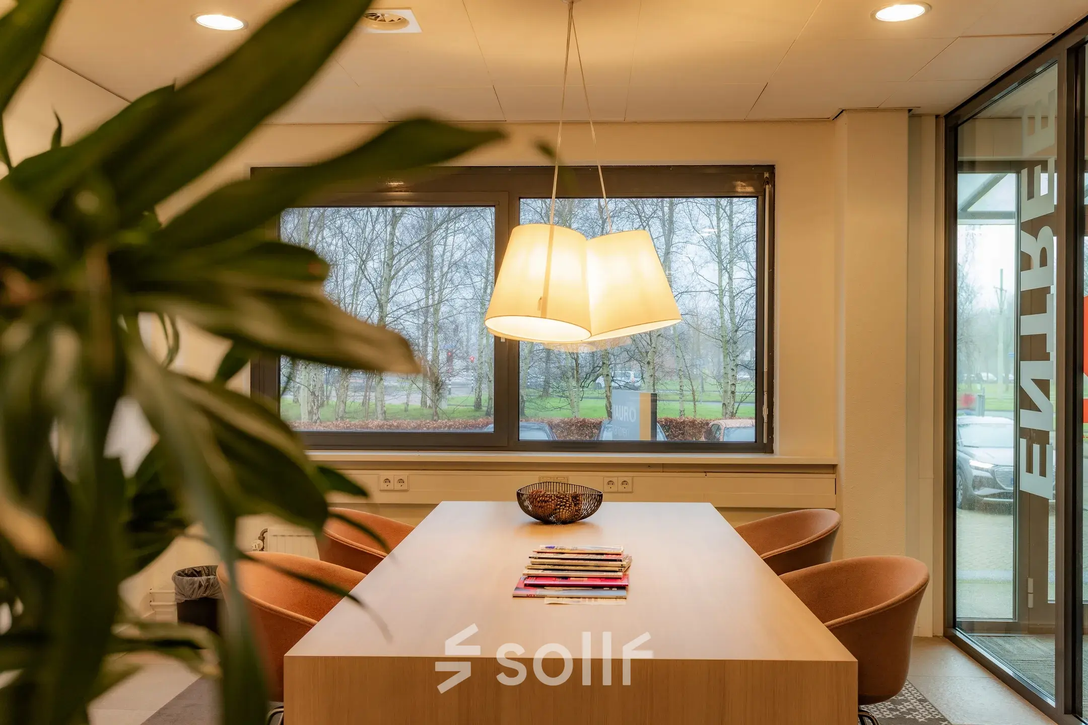 Office to rent at Marshalllaan 2, Delft, featuring a furnished interior with a large wooden table, comfortable chairs, and natural light from surrounding windows. Ideal for office space rental.