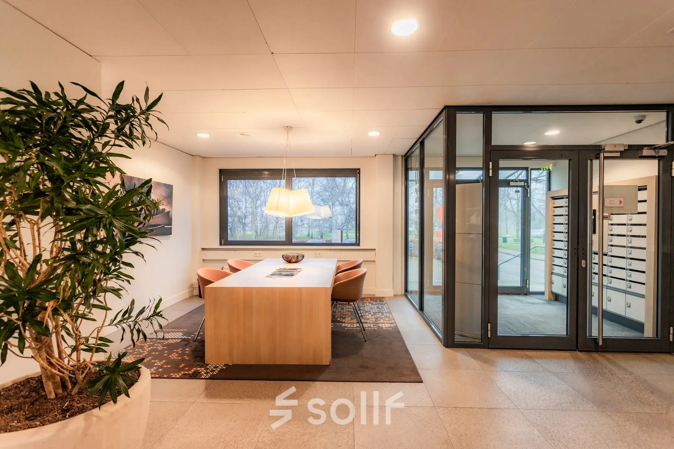 A tastefully furnished office to rent at Marshalllaan 2, Delft, featuring a sleek conference room with a large table, comfortable chairs, and bright lighting. Ideal for office space rental.