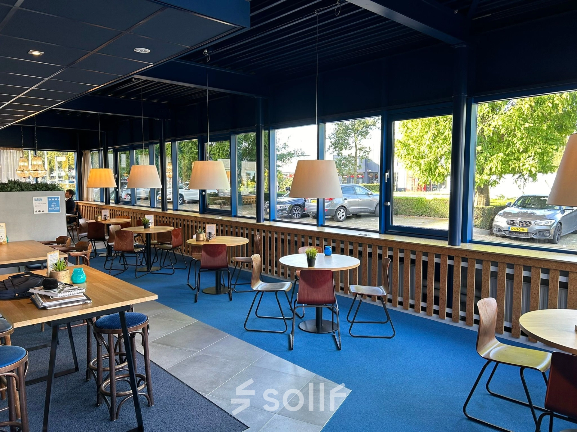 Bright office space with large windows and several round tables with chairs, ideal for office space rental at Amerikastraat 3, Den Bosch.