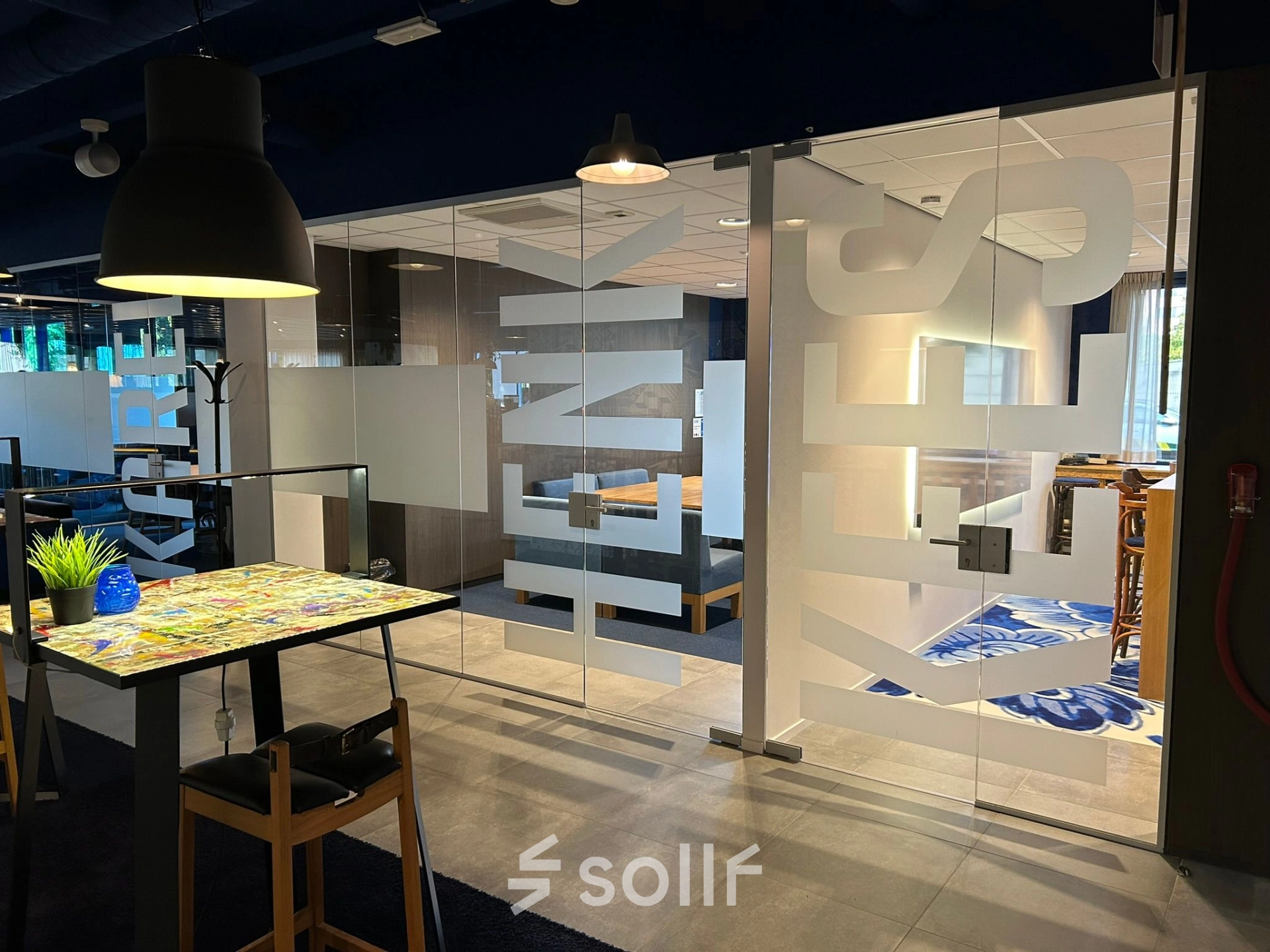 Furnished office space for rent at Amerikastraat 3, Den Bosch, featuring a modern glass-walled meeting area with vibrant decor. Ideal for office space rental needs.