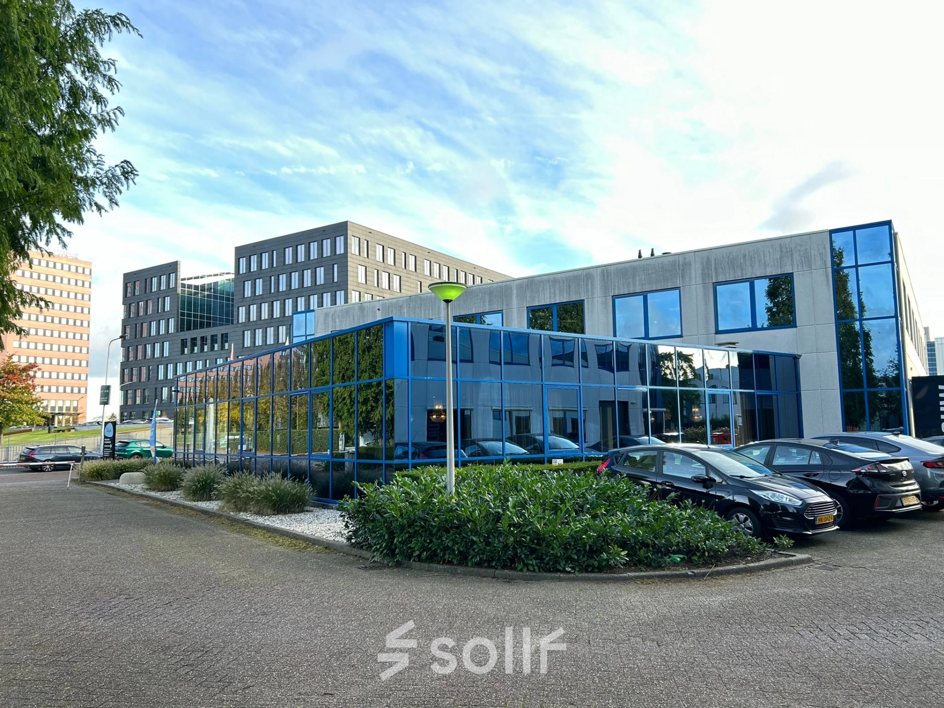 Exterior view of an office building at Amerikastraat 3, Den Bosch, showcasing modern architecture with reflective glass facade, perfect for office space rental.