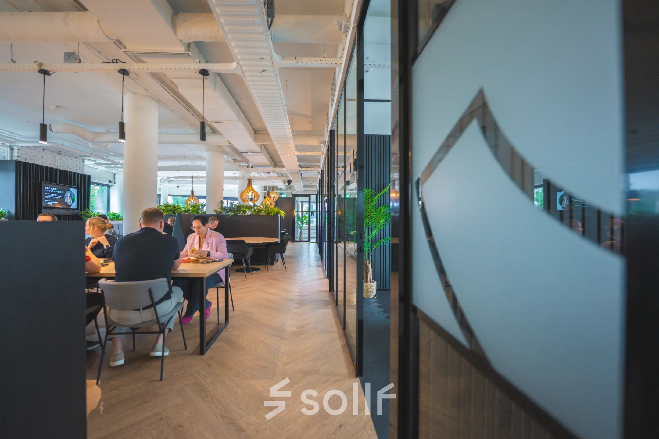 Business professionals collaborating in a modern, furnished workspace at Hambakenwetering 1, Den Bosch, ideal for office space rental.