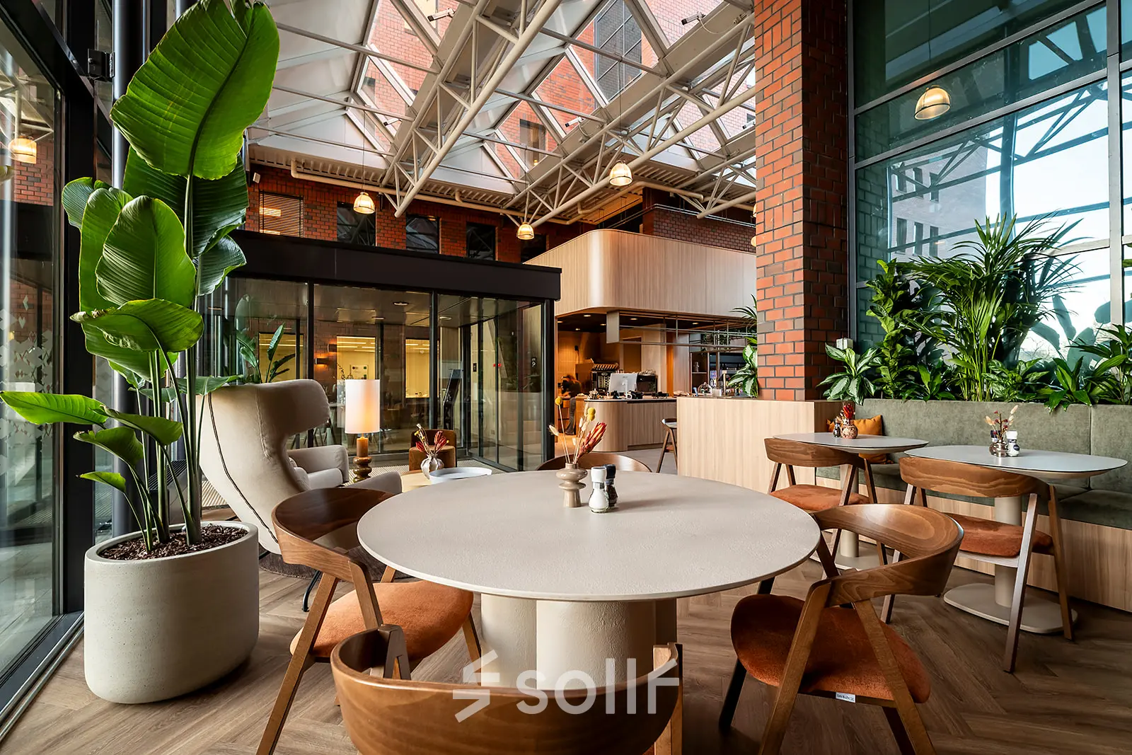 Inviting office space rental with stylish furniture at Hambakenwetering 5, Den Bosch, featuring modern seating and lush plants, ideal for collaborative work.