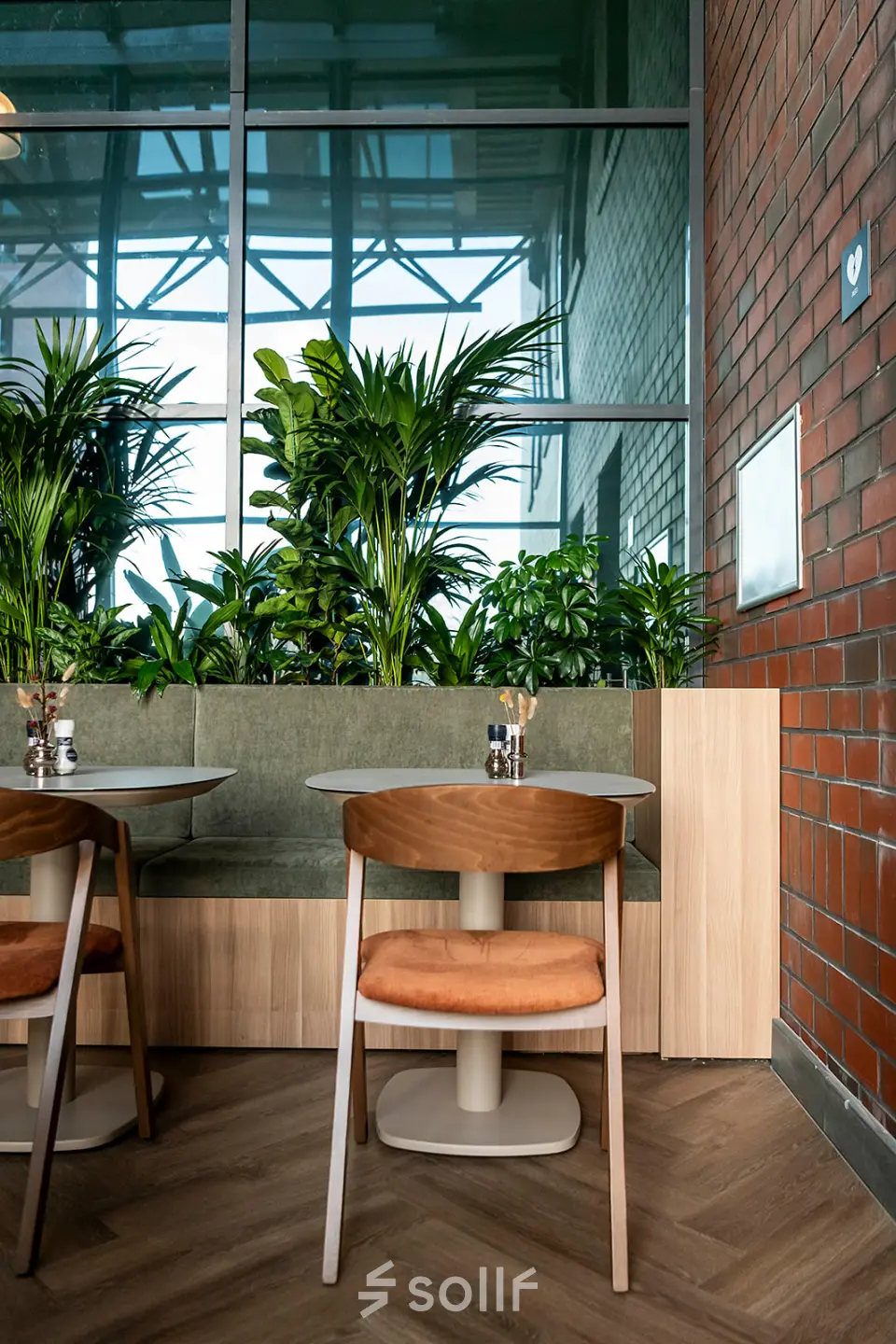 Interior office space in Den Bosch with tables, chairs, and greenery, ideal for office space rental.