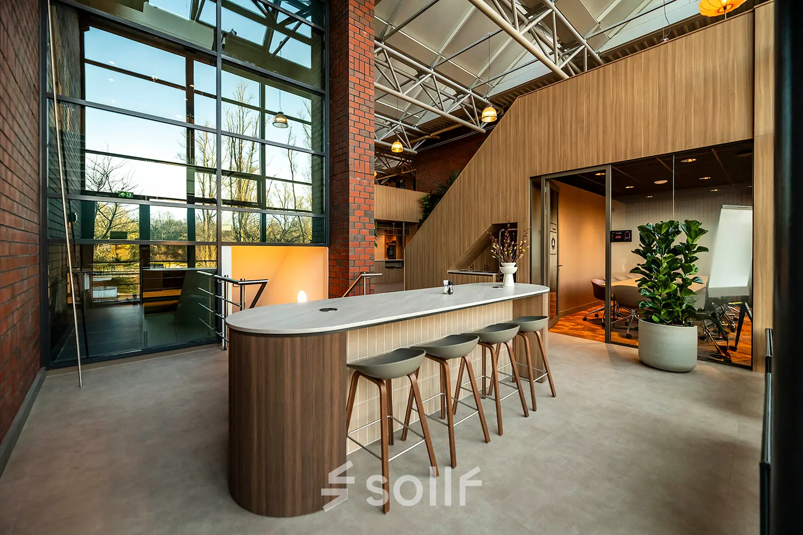 Interior view of a modern office to rent at Hambakenwetering 5, Den Bosch, showcasing a stylish furnished lounge and workspaces with natural light.