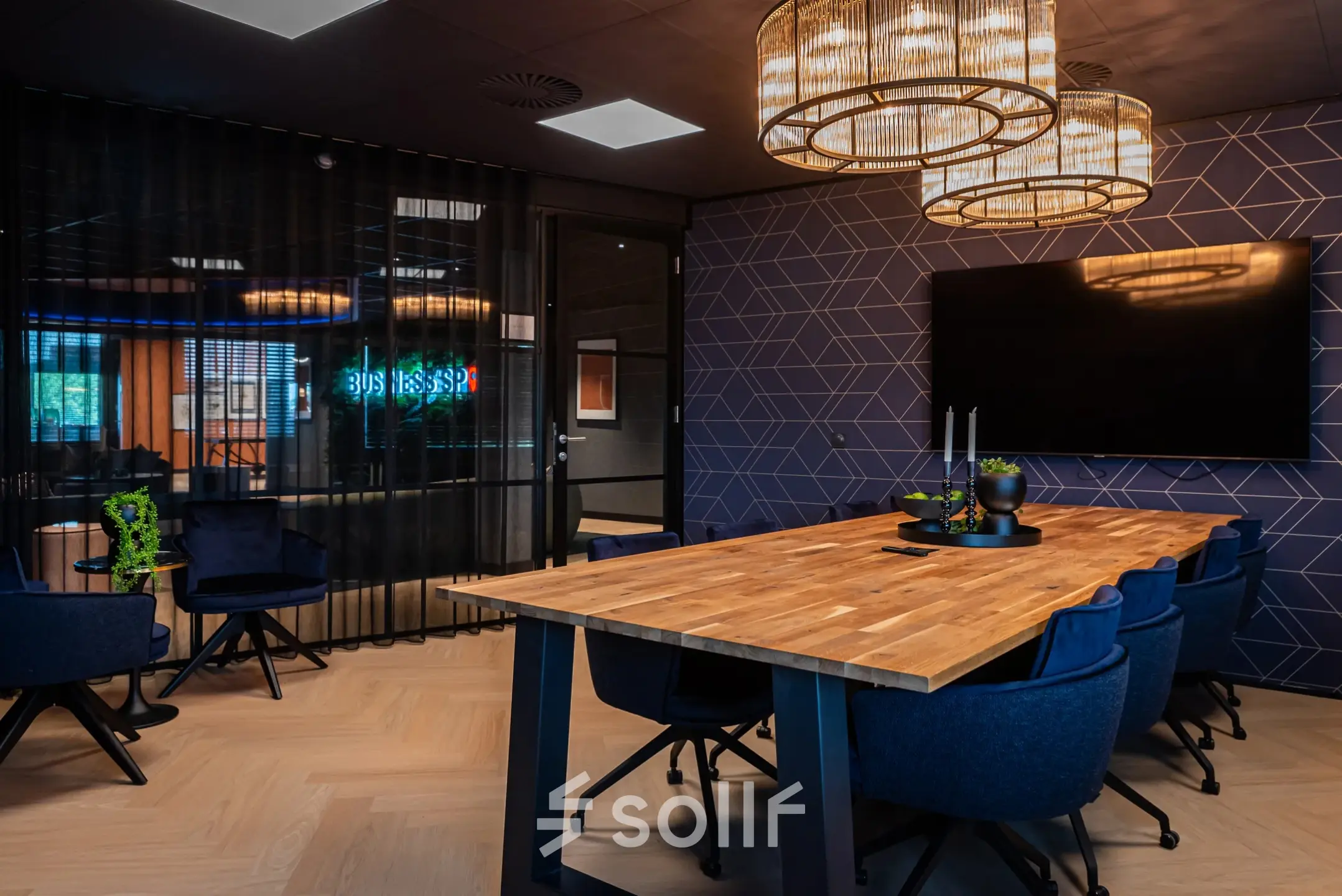 Modern conference room available for office space rental at Reitschweg 1, Den Bosch, featuring a wooden table, blue chairs, and stylish lighting.