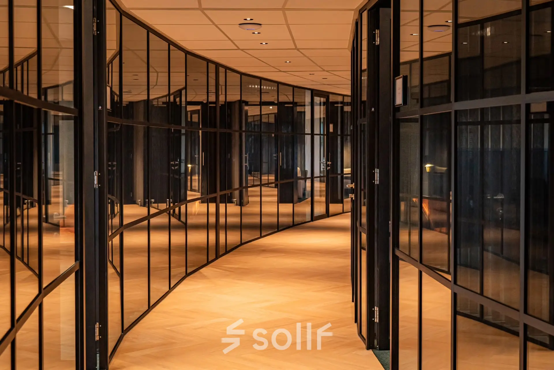 Curved glass-walled office corridor at Reitschweg 1, Den Bosch, ideal for office space rental.