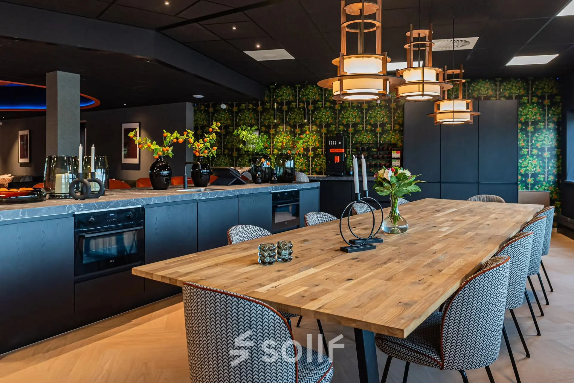 Modern, stylish office space with a wooden table surrounded by patterned chairs and ambient lighting, perfect for an office to rent at Reitschweg 1, Den Bosch.