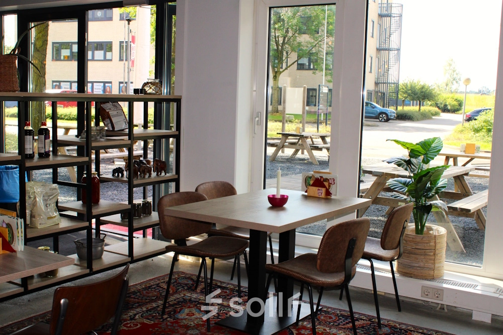 Cozy office space at Keulenstraat 10, Deventer, featuring a furnished area with tables, chairs, and a view of the outdoors, ideal for office space rental.