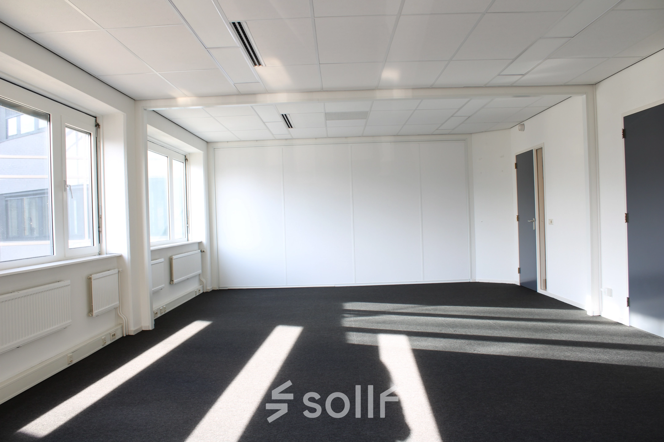 Unfurnished office space with large windows allowing natural light at Keulenstraat 12, Deventer, ideal for office space rental.