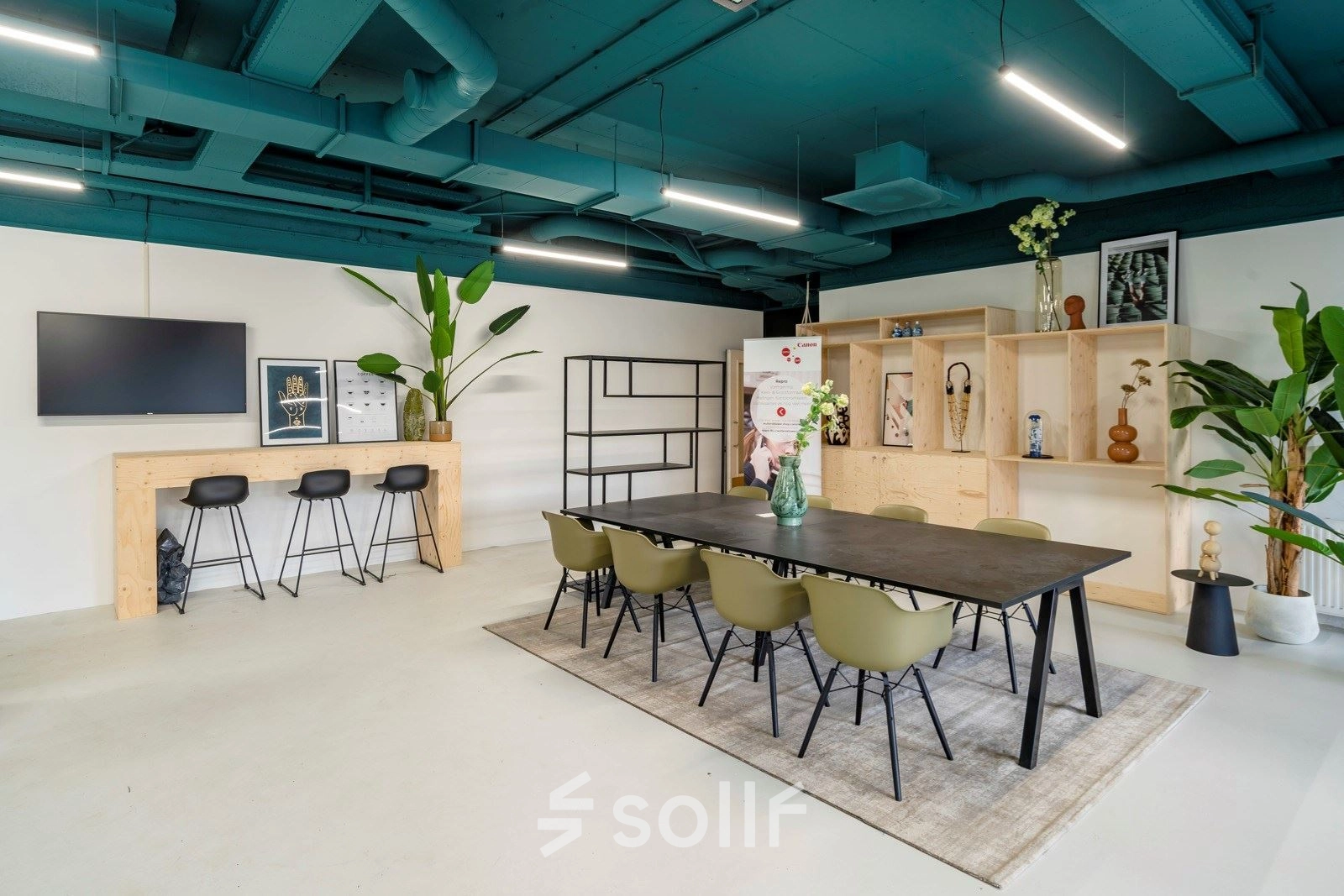 Spacious office to rent at Staverenstraat 15-17 in Deventer featuring a stylish meeting table, bar stools, and decorative elements for an inviting office space rental experience.