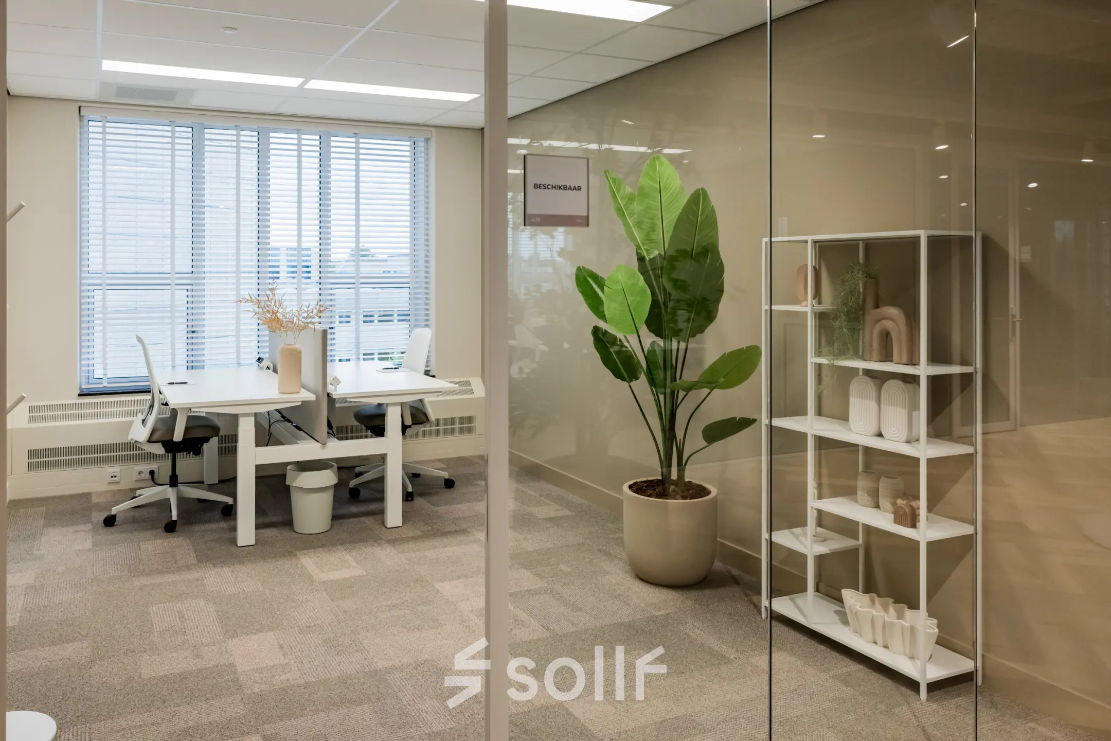 Bright and modern office space for rent at Diemerhof 42 in Diemen, featuring large windows, desks, and decorative elements for a comfortable working environment.