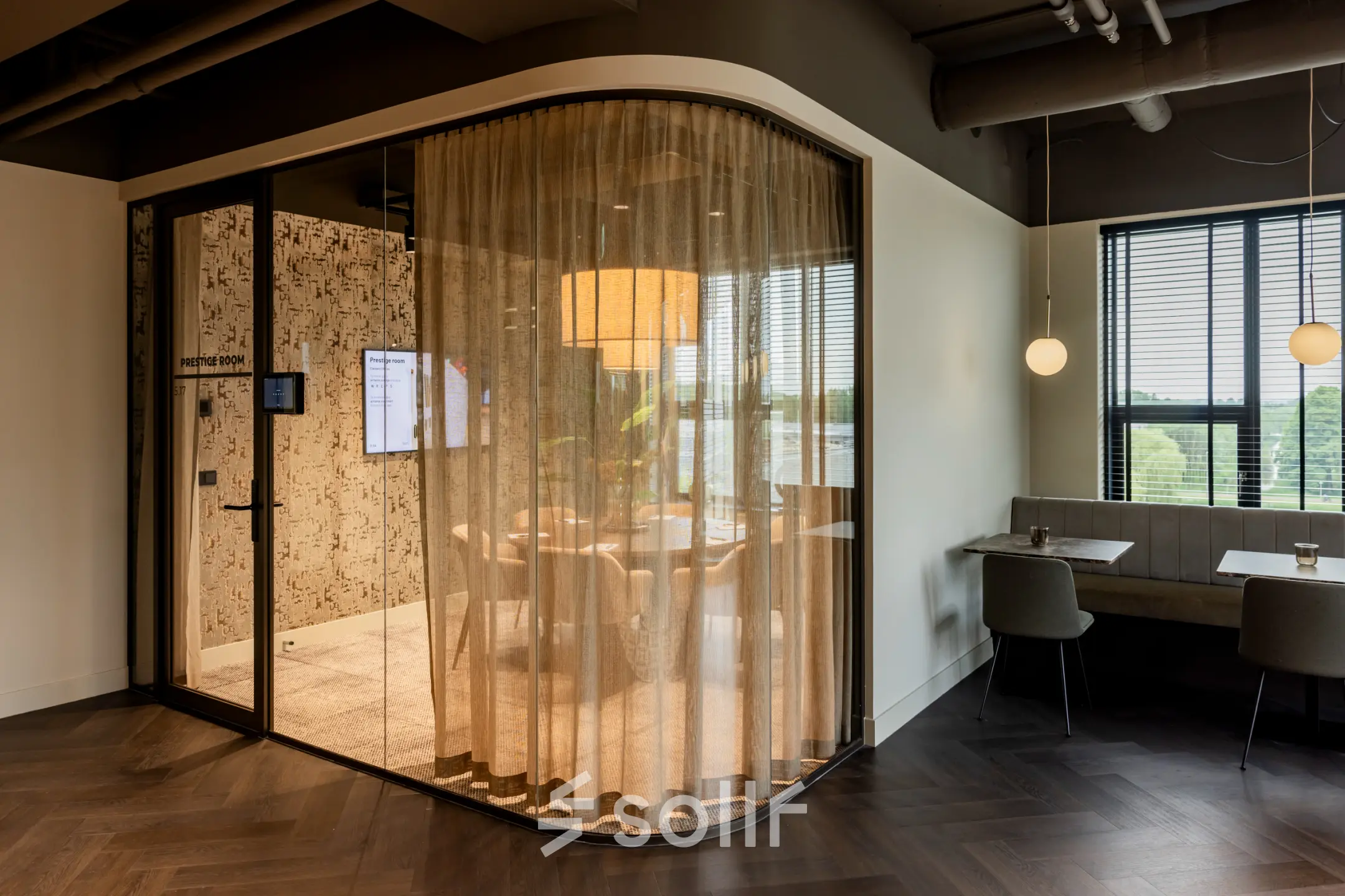 A modern office space at Diemerhof 42, Diemen, featuring a stylish conference room with glass walls and surrounding seating area, ideal for office space rental.
