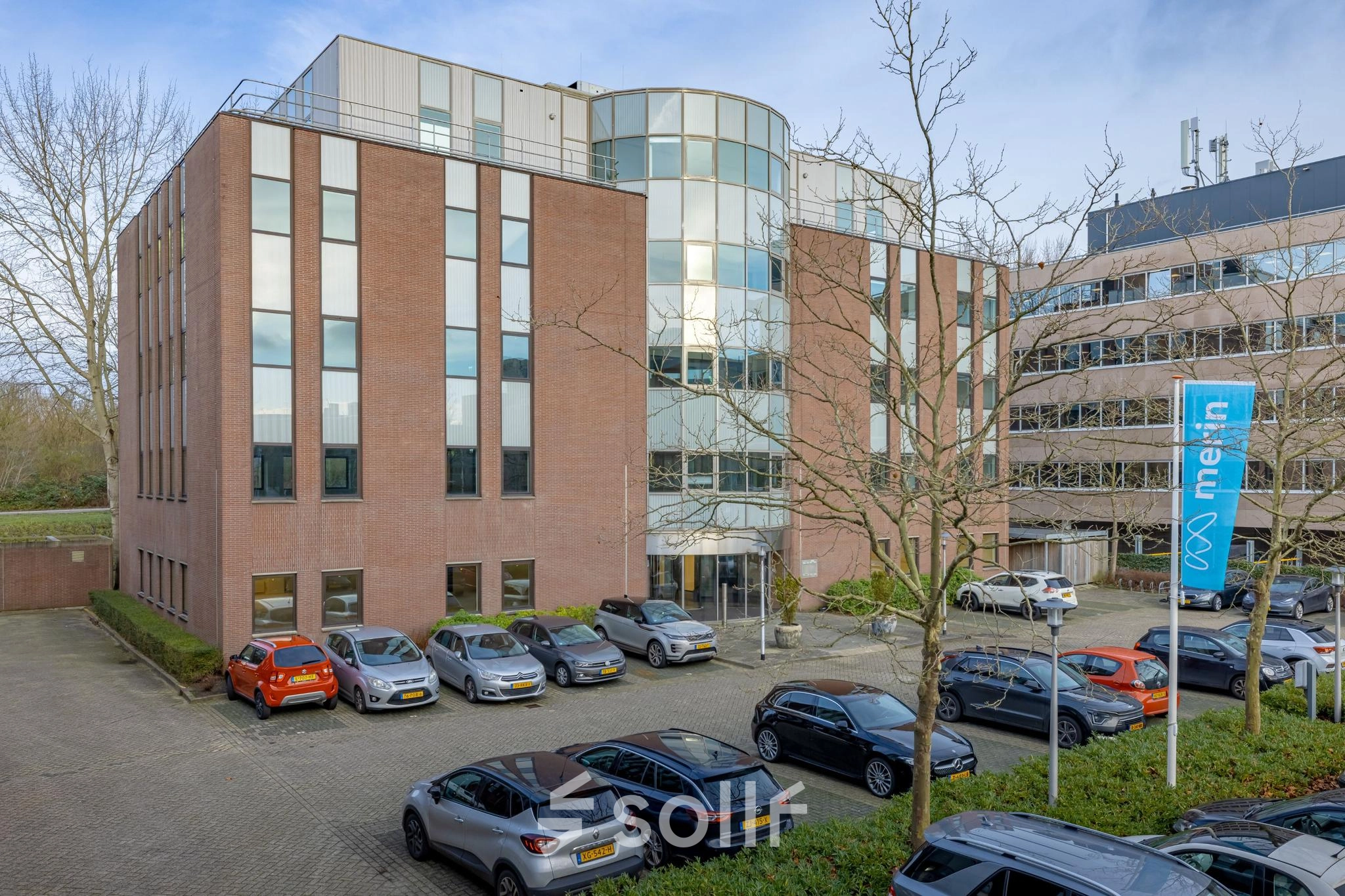 Exterior view of an office building at Wisselwerking 40-48, Diemen, showcasing available office space rental opportunities, with a parking area in front.