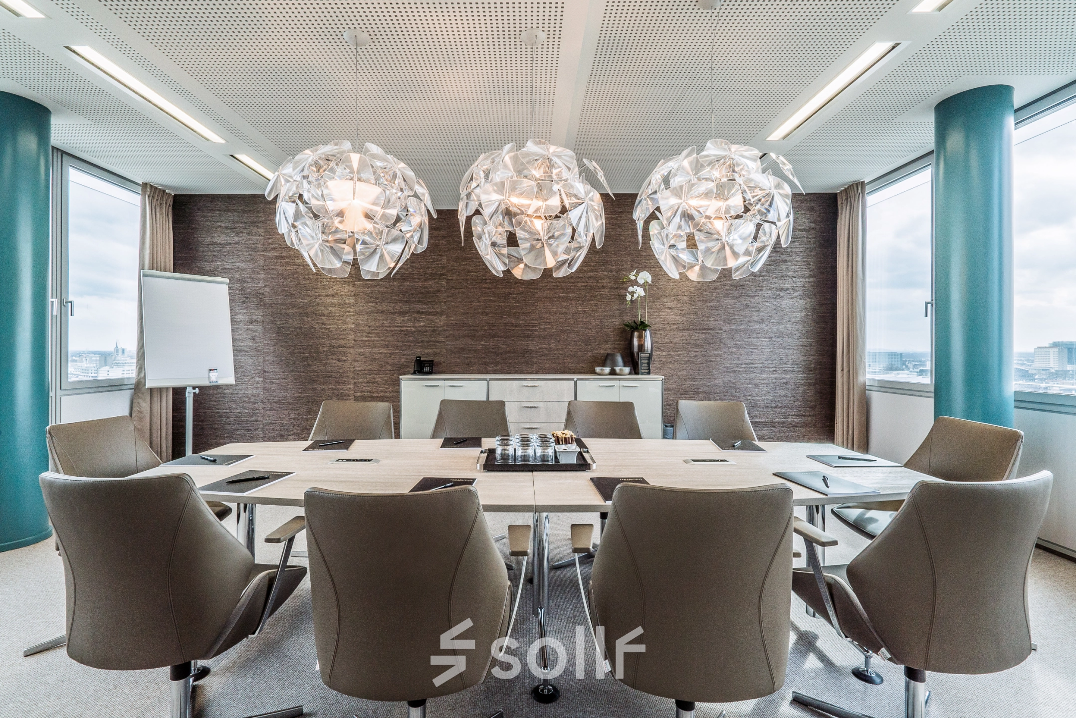 Stylish conference room with modern lighting and large meeting table, located in Dreischeibenhaus 1, perfect for office space rental in Düsseldorf Old Town.