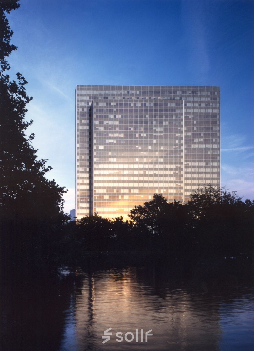 Exterior view of Dreischeibenhaus at dusk, a key location for office space rental in Düsseldorf Old Town (Königsallee).