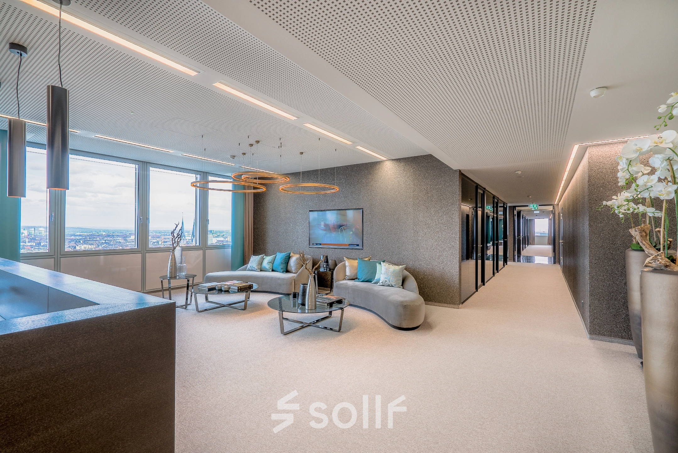 Bright, furnished office space with a seating area and large windows offering city views in Düsseldorf Old Town, perfect for office space rental.