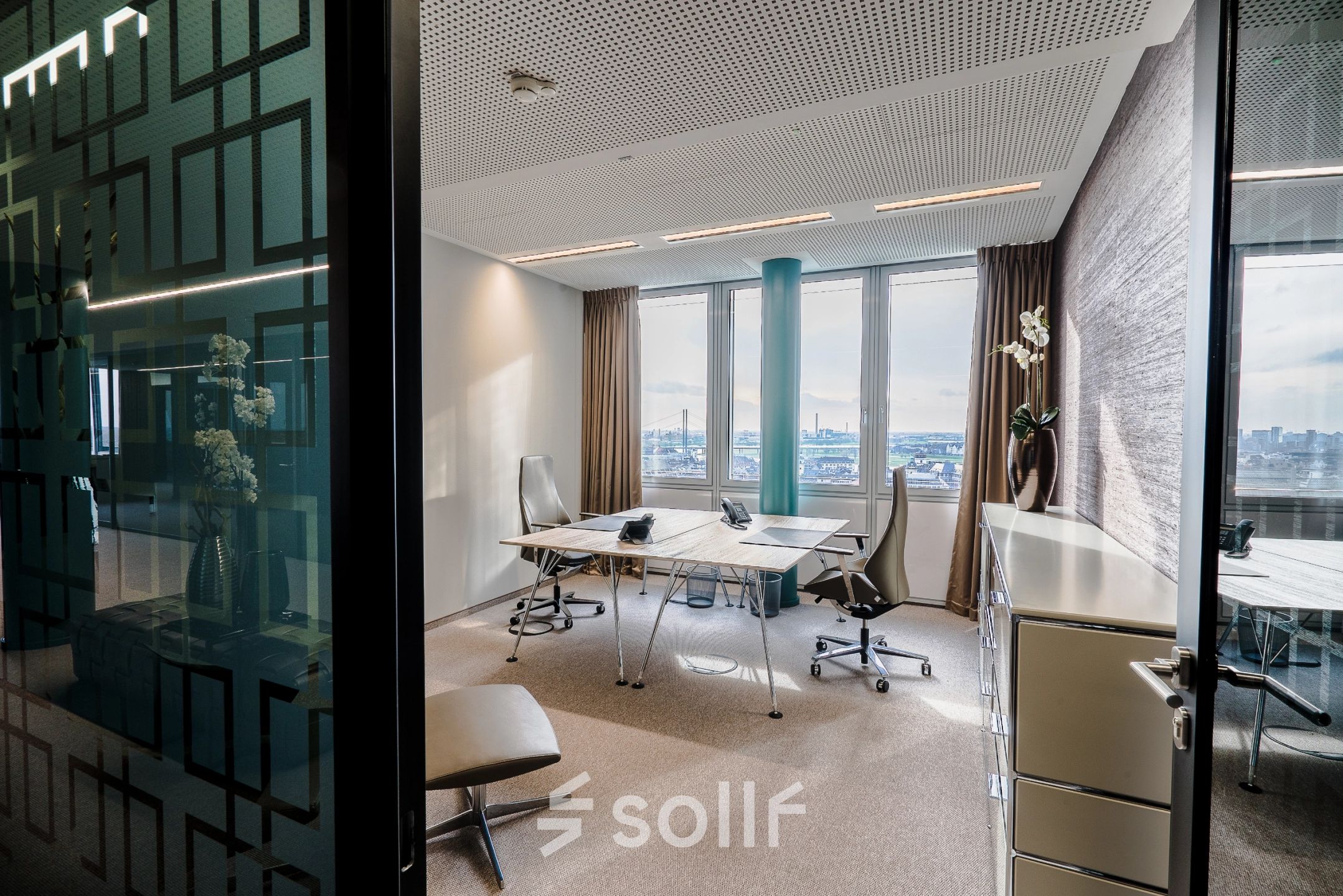 Bright office space rental in Dreischeibenhaus, Düsseldorf Old Town, featuring modern furnishings and large windows with city views, offering an ideal workspace environment.