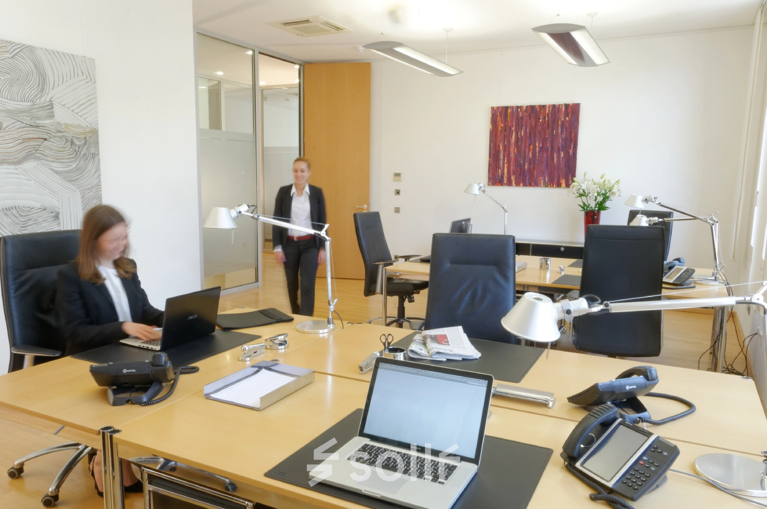 Modern office space at Königsallee 14, Düsseldorf Old Town with professionals working on laptops. Suitable for office space rental.