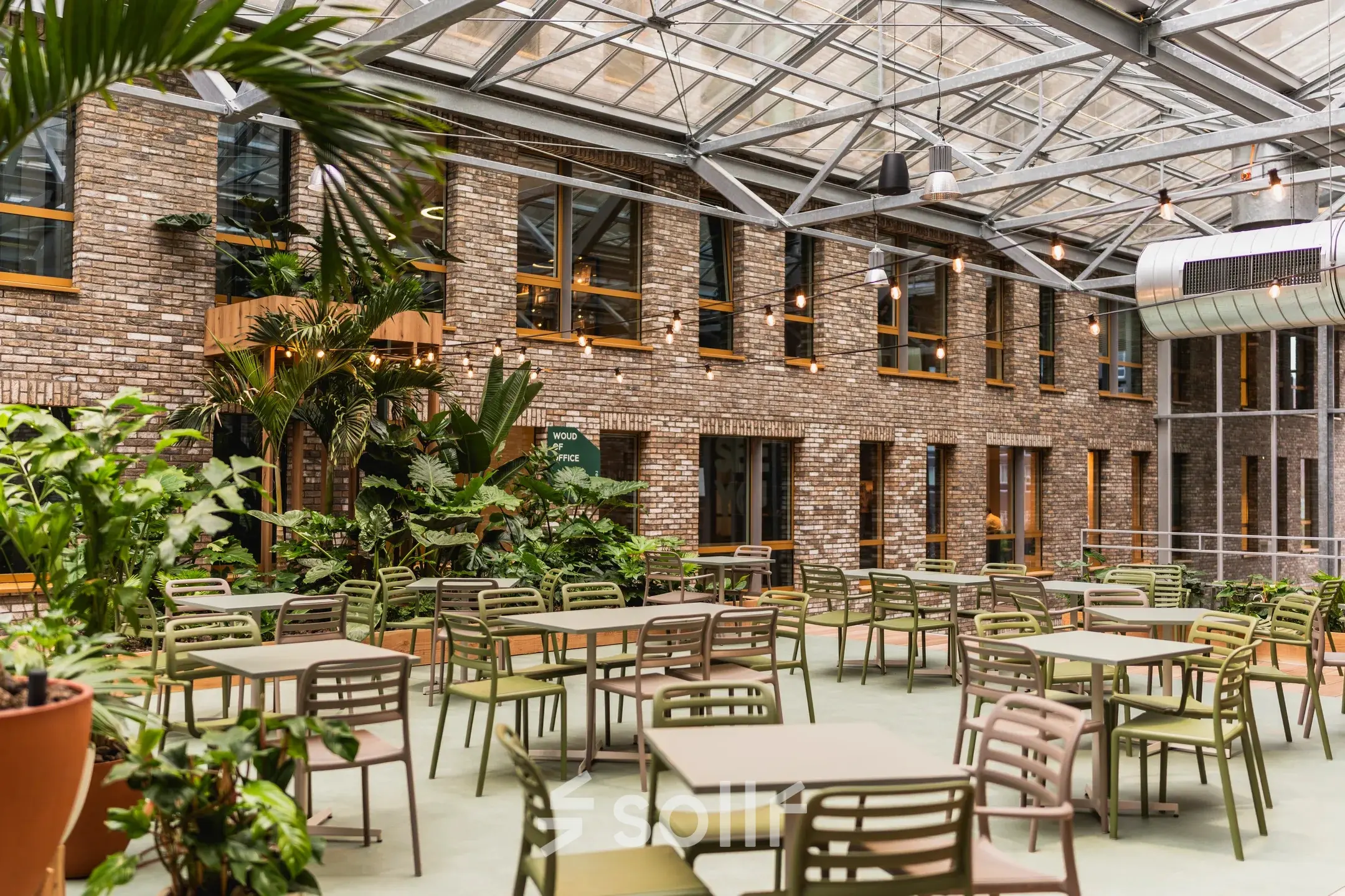 Atrium with abundant seating and greenery at Flight Forum 120-159, ideal for office space rental.
