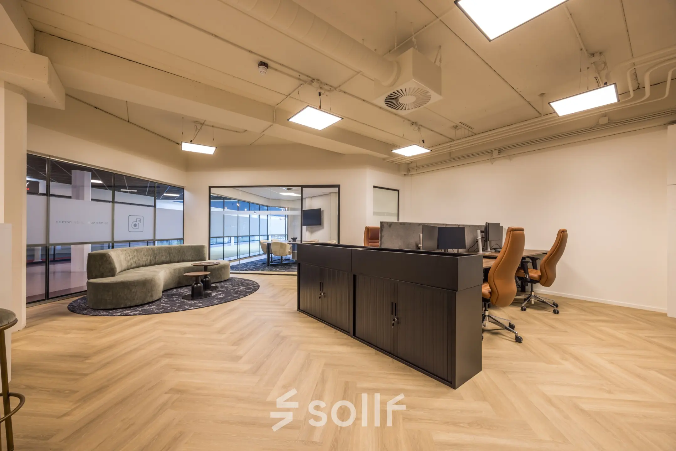 Modern office space at Luchthavenweg 81, Eindhoven Airport, featuring sleek desks and a curved couch, perfect for office space rental.