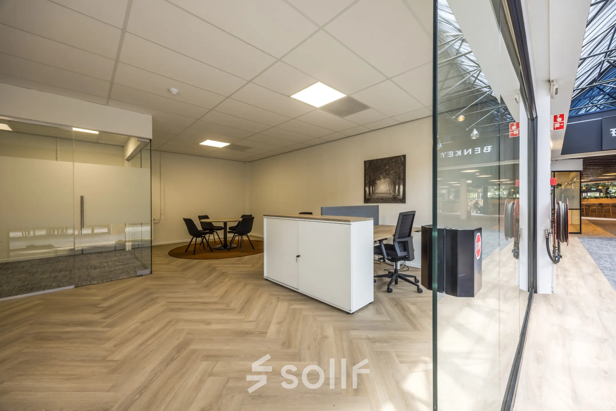 Modern office space with glass walls and wood flooring at Eindhoven Airport, ideal for those seeking office space rental with sleek furnishings.