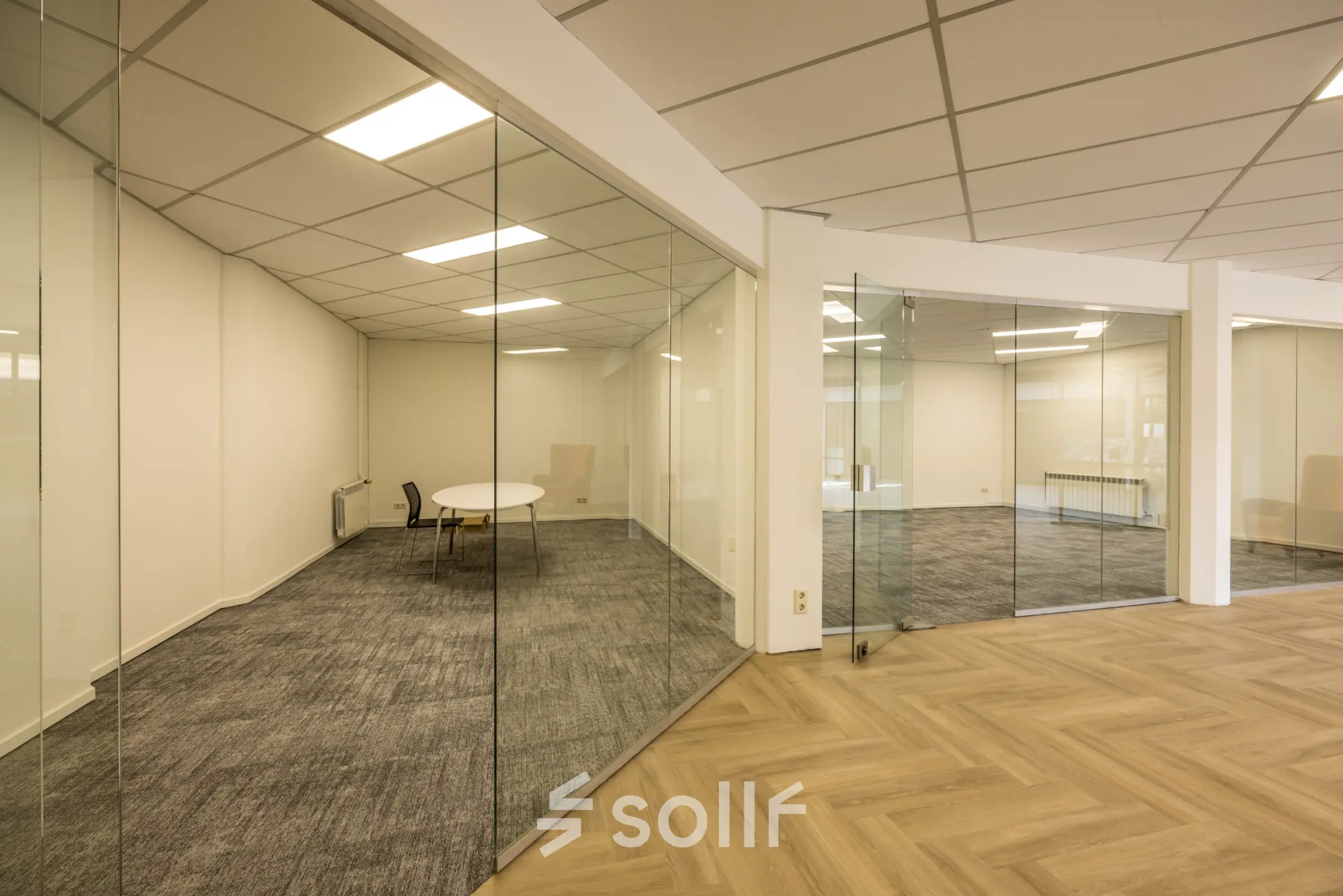 Spacious office to rent at Luchthavenweg 81, Eindhoven Airport with glass partitioning and carpeted flooring, ideal for office space rental needs.