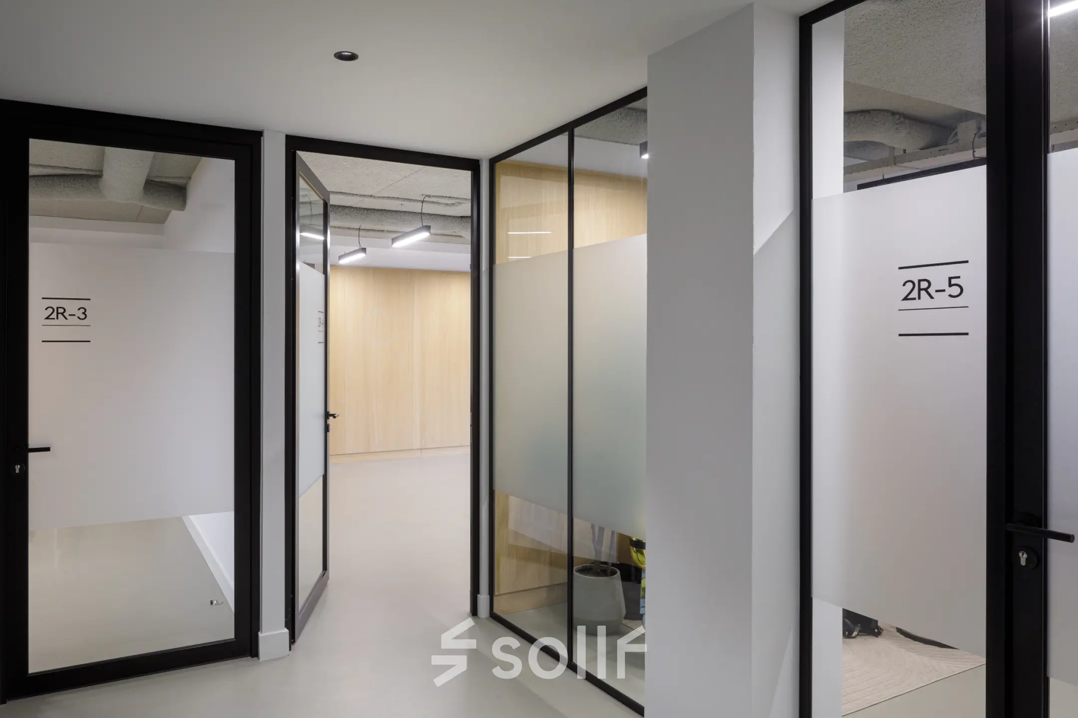 Spacious office hallway at Paradijslaan 30-38 in Eindhoven Center, featuring modern glass doors. Ideal for office space rental with easy navigation between rooms.