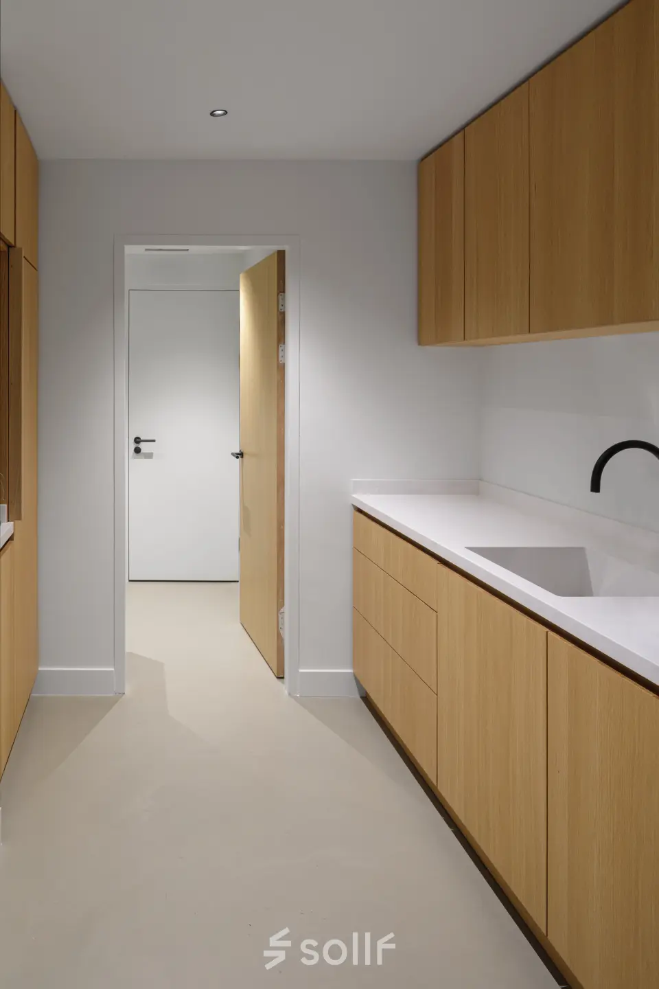 Modern office space rental at Paradijslaan 30-38, Eindhoven Center, featuring a sleek, minimalistic kitchen area with wooden cabinetry and a streamlined design.