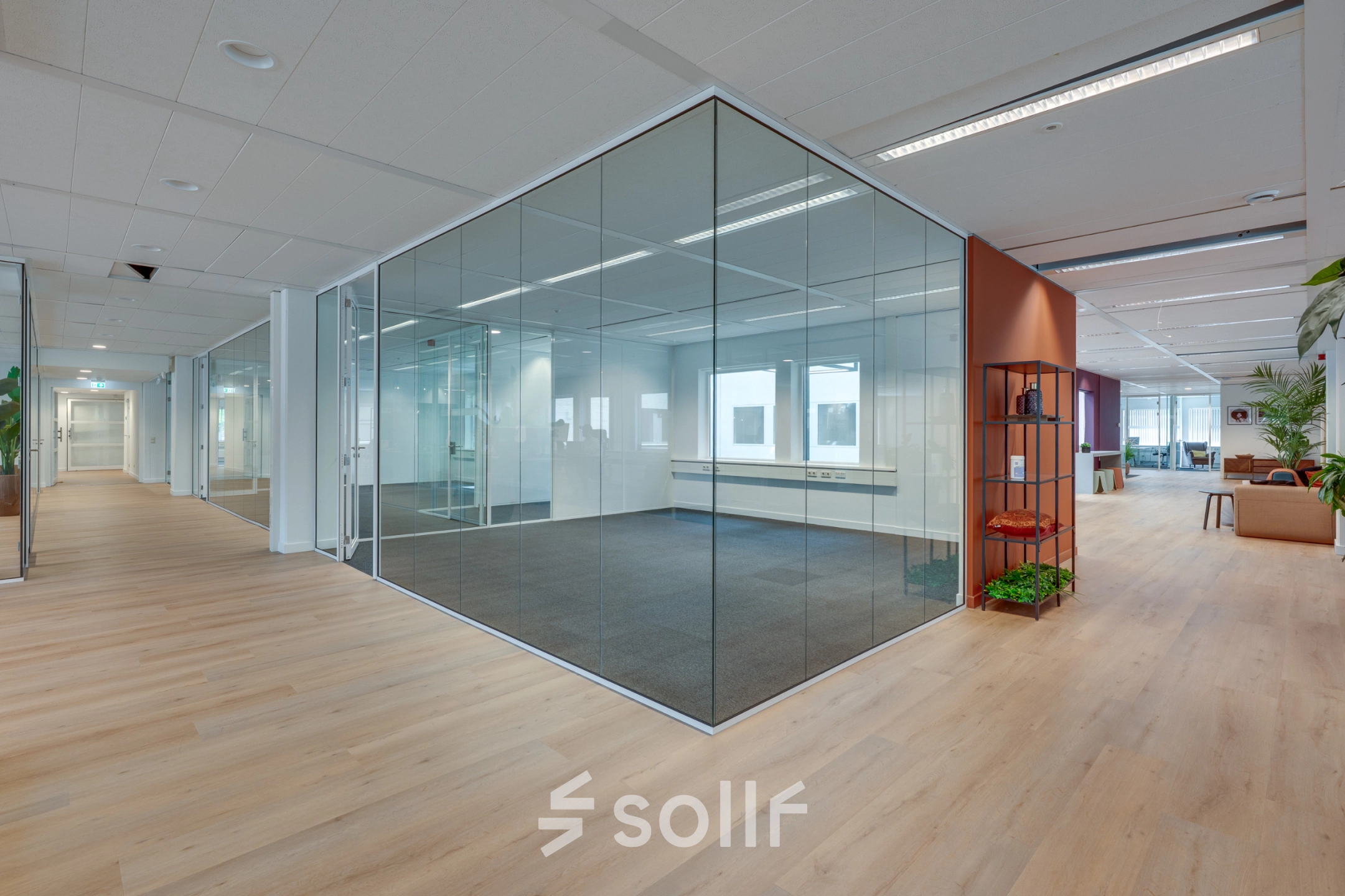 Modern office to rent at Stadhuisplein 10, Eindhoven Center, featuring open floorplan with glass walls and greenery. Ideal for office space rental.