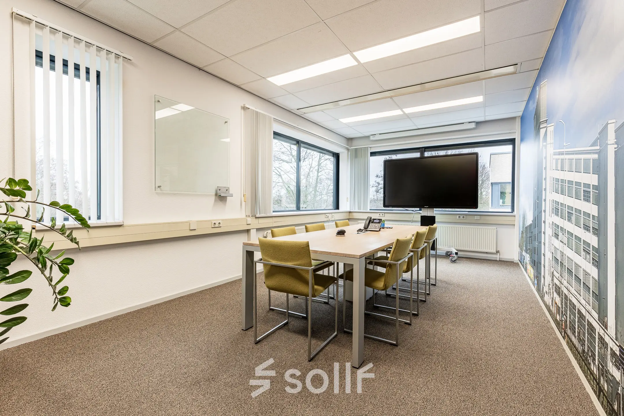 Bright office space with a conference table, chairs, and a large screen at Meerenakkerplein 11-20, perfect for office space rental in Eindhoven De Hurk.