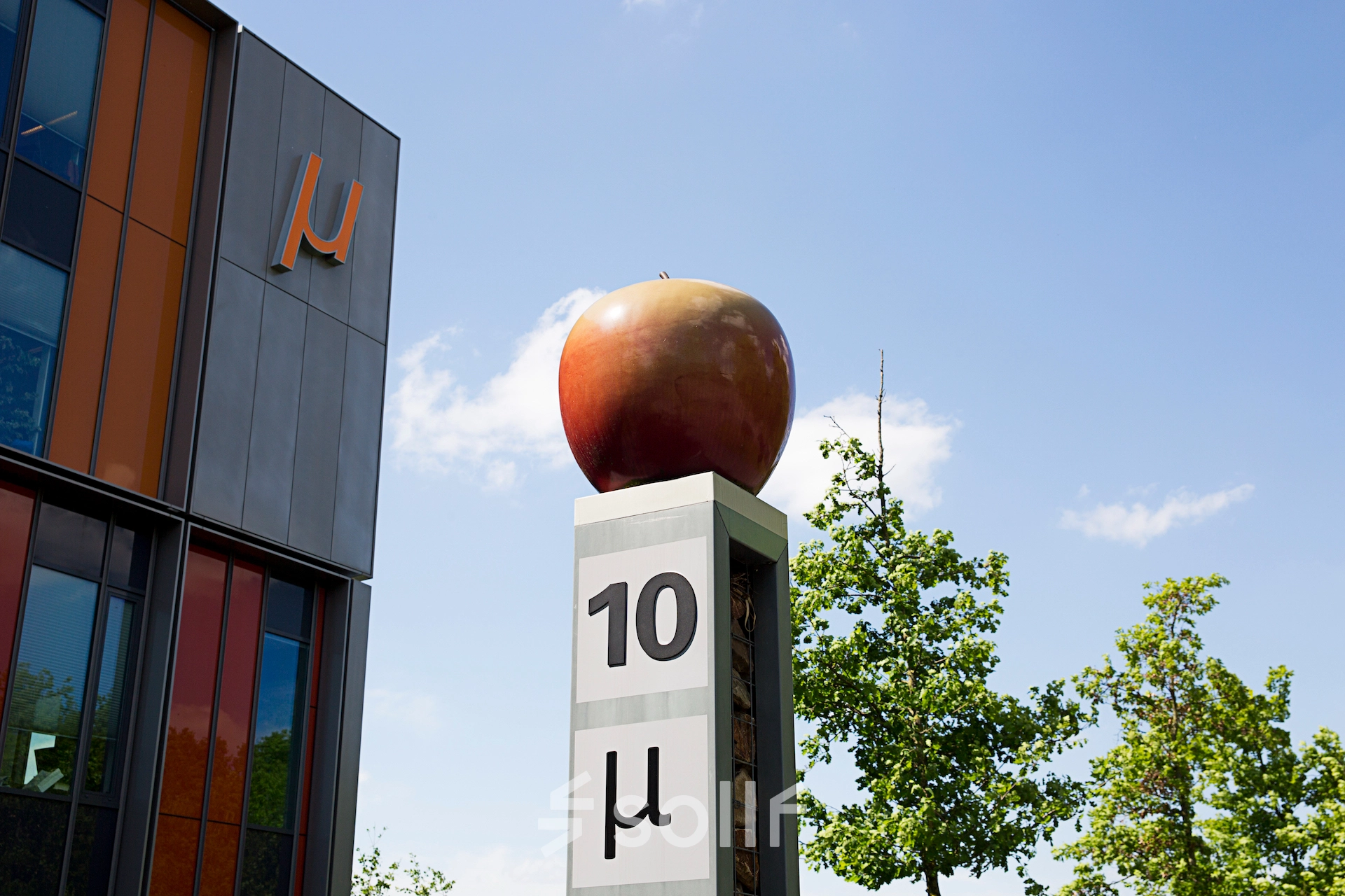 Exterior view of High Tech Campus 10 in Eindhoven, featuring modern architecture and symbolic apple art, ideal for businesses seeking office space rental in a cutting-edge innovation environment.