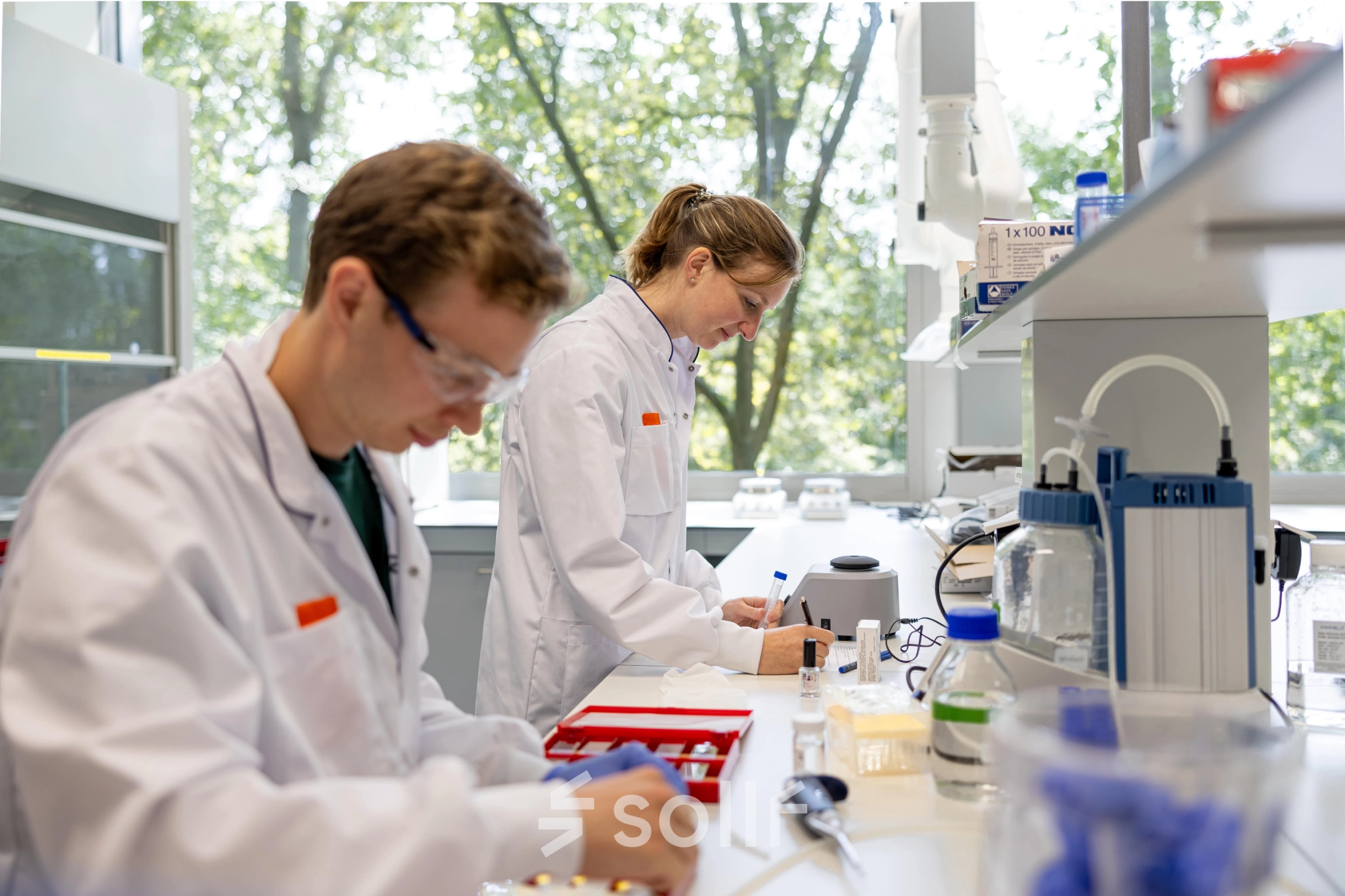 Scientists conduct experiments in a bright, modern laboratory at High Tech Campus 10, Eindhoven, suitable for office space rental.