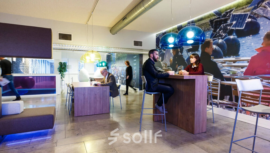 Modern office interior at TU campus, Eindhoven, featuring high tables and engaging workspaces. Ideal for those seeking office space rental in a vibrant, collaborative environment.