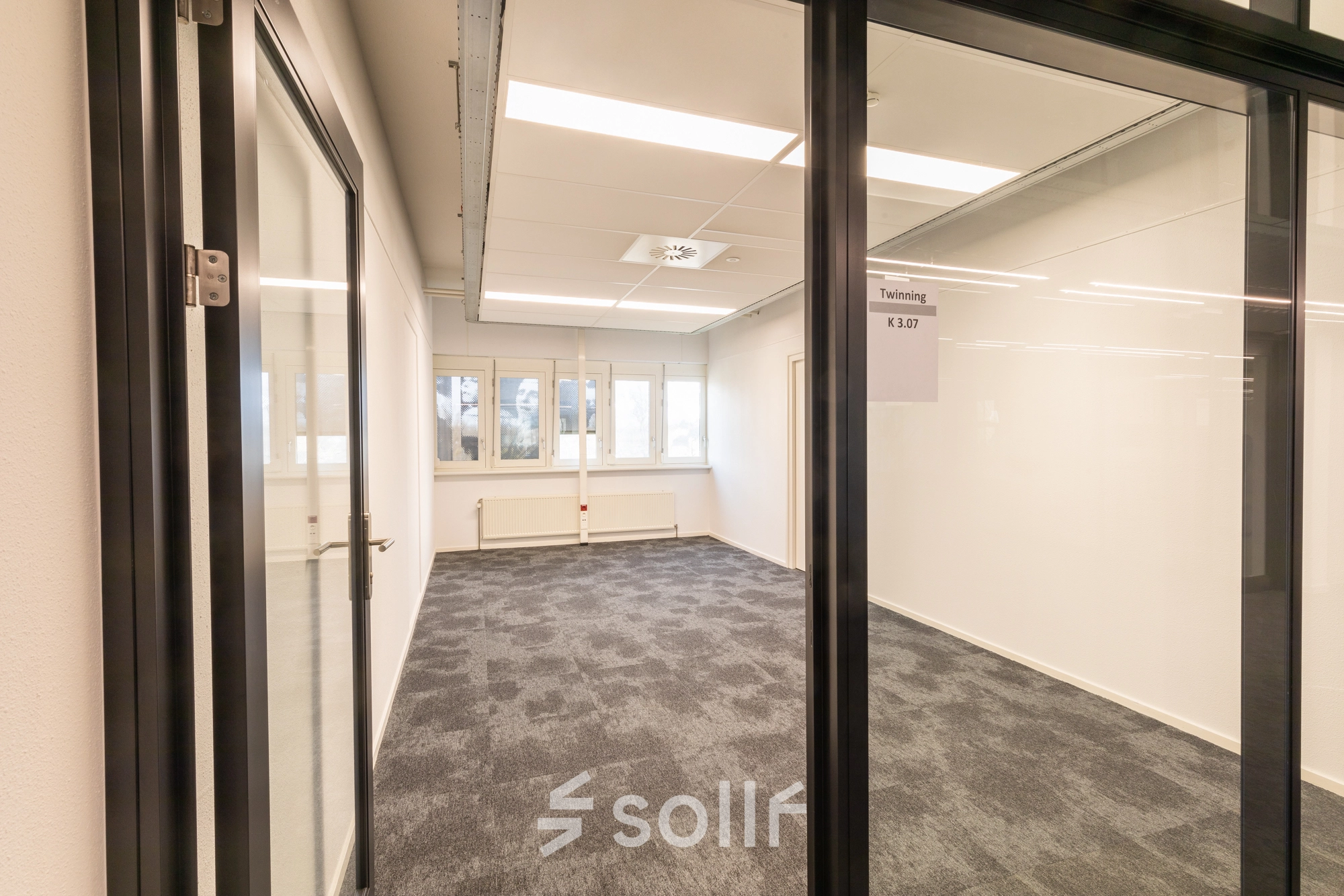 Unfurnished office space rental at TU campus De Zaale 11, Eindhoven High Tech Campus, featuring modern carpet and ample natural light from multiple windows.