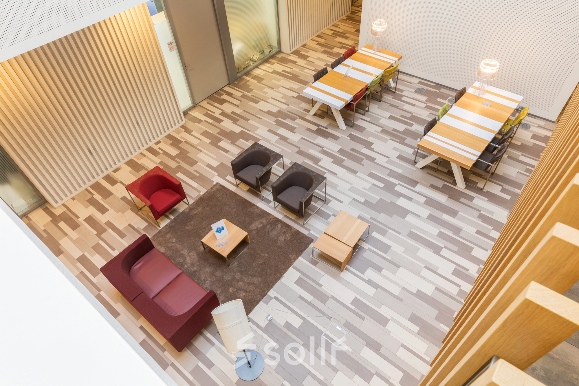 Bright office space for rent at TU Eindhoven High Tech Campus. Features modern furnishings with seating and tables, ideal for workspace or office space rental.