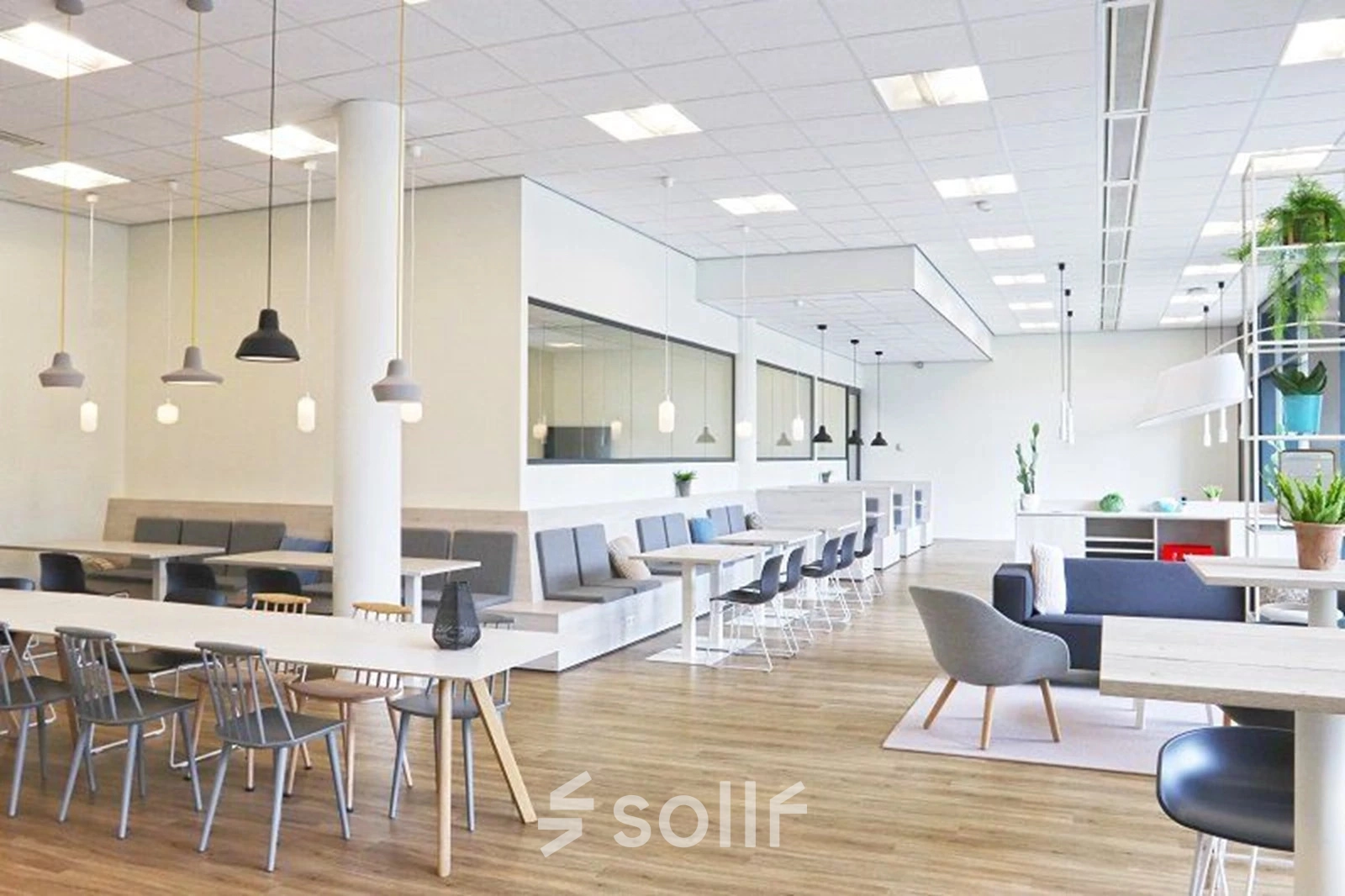 Bright office space with modern furniture, featuring several tables and chairs arranged for collaborative work at Anderlechtstraat 15 in Eindhoven North. Ideal for office space rental.