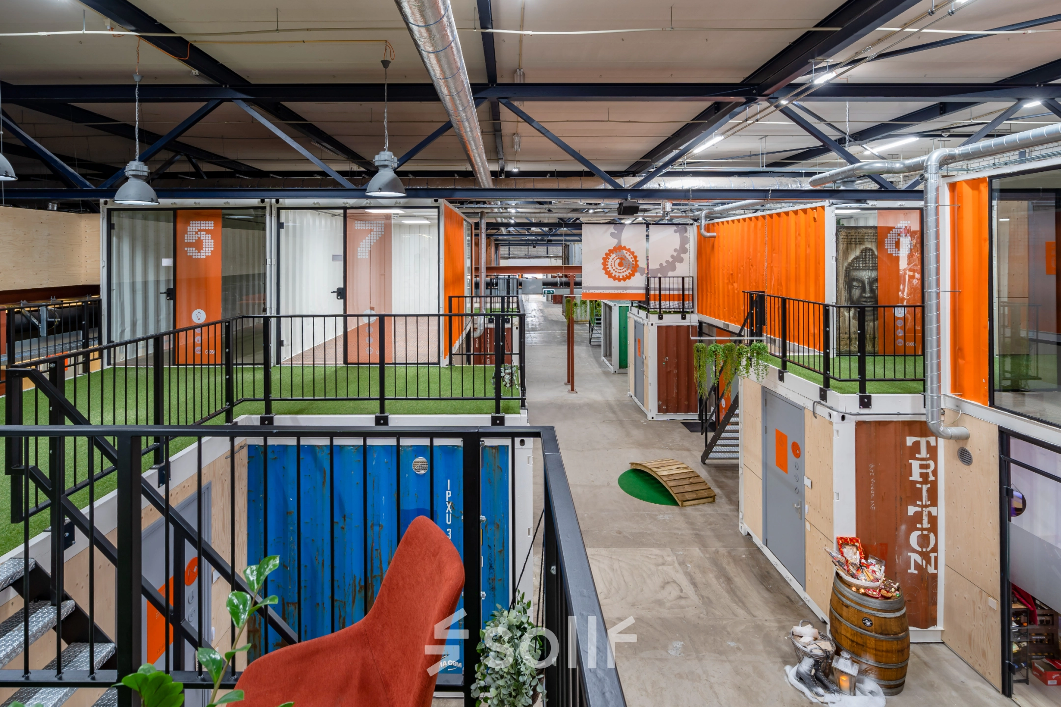 Colorful, creatively designed interior at Tarasconweg 2, Eindhoven North, featuring vibrant shipping container workspaces available for rent. Modern industrial style with open flooring and vibrant accents.