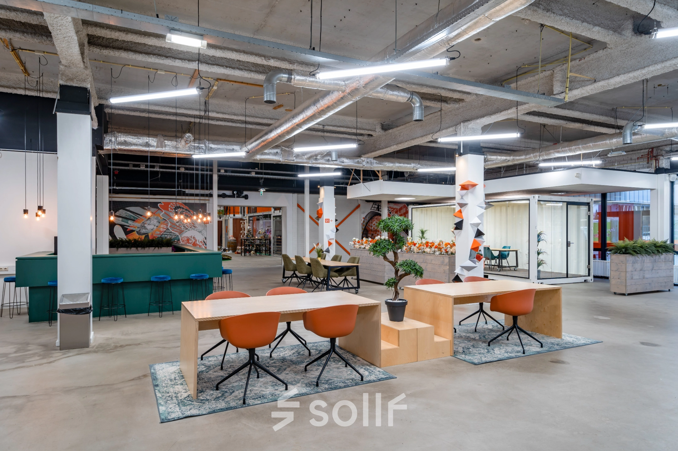 Modern open workspace at Tarasconweg 2, Eindhoven North, featuring contemporary desks, vibrant chairs, and creative lighting, ideal for office space rental.