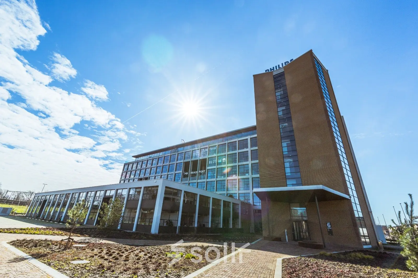 Exterior view of the office building at Achtseweg Zuid 159R, Eindhoven Strijp-S, showcasing a modern structure with clear skies, ideal for office space rental.