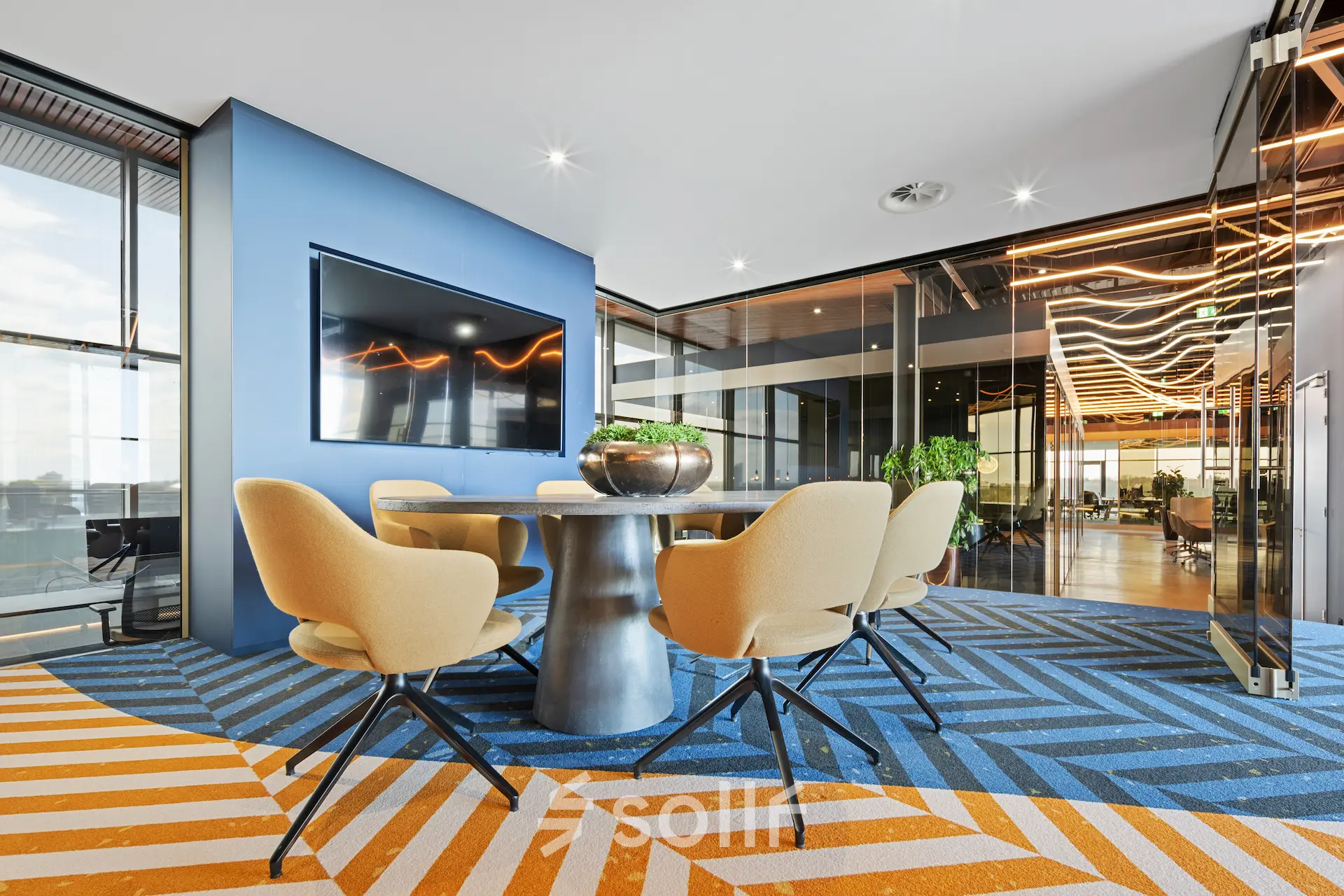 A modern meeting room with a sleek table, chairs, and a large TV in an office to rent at Achtseweg Zuid 159R, Eindhoven Strijp-S.