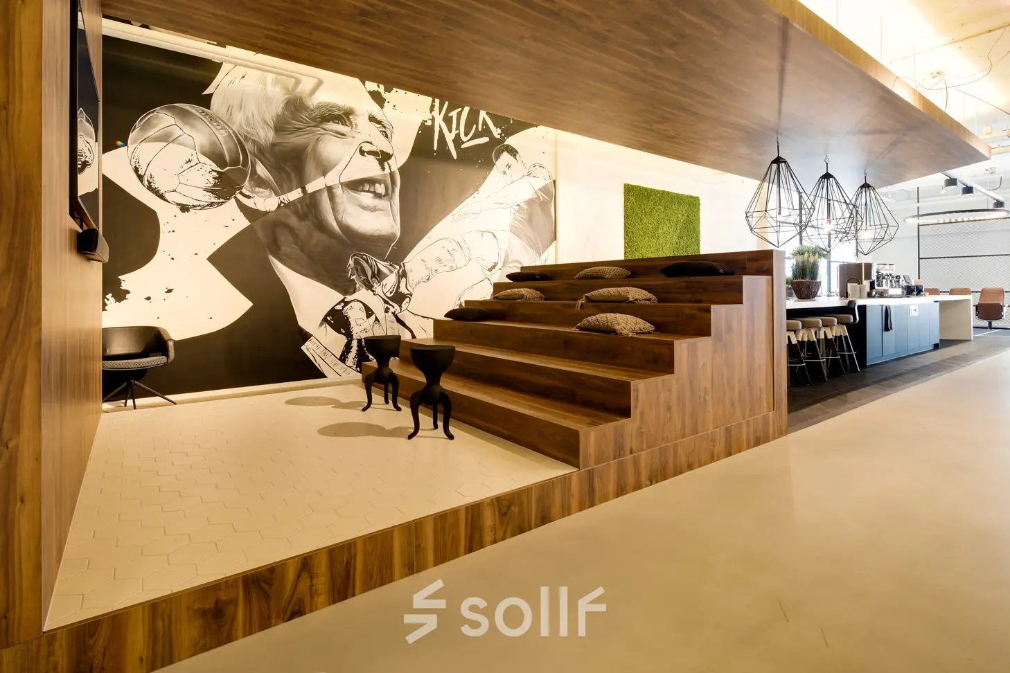 Contemporary office space at Frederiklaan 10E, Eindhoven Strijp-S, featuring wooden tiered seating with cushions and a stylish wall mural, available for office space rental.