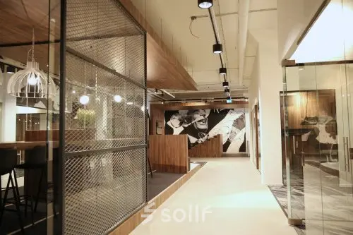Modern office space at Frederiklaan 10E, Eindhoven Strijp-S, featuring artistic decor, glass walls, and seating areas available for office space rental.
