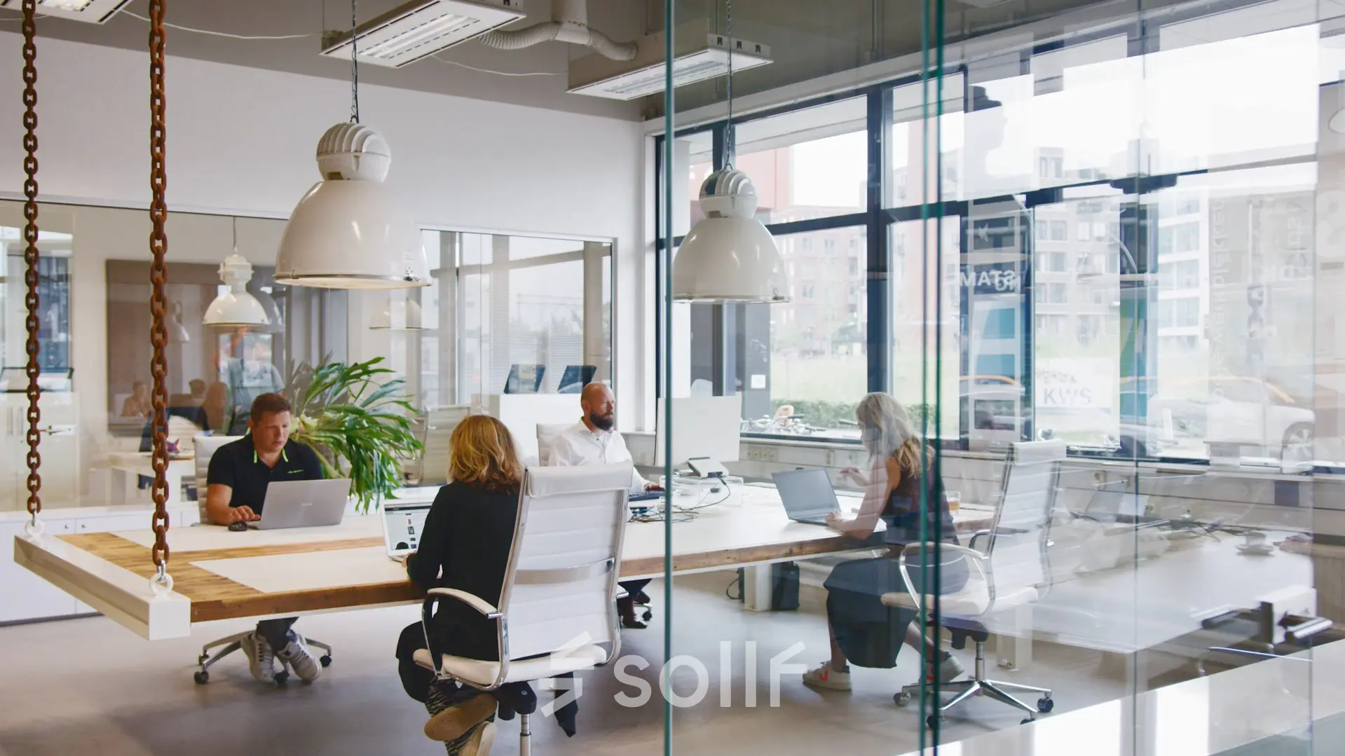 Office space rental at Torenallee 20, Eindhoven Strijp-S, featuring a modern interior with glass walls and people engaged in business activities at desks.