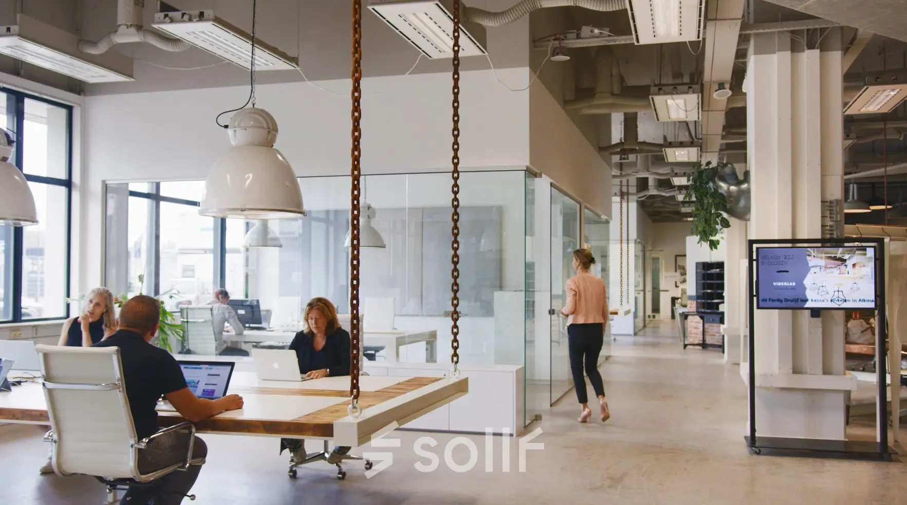 Office space rental at Torenallee 20, Eindhoven Strijp-S, featuring an open floor plan with modern furnishings and professionals engaged in collaborative work.