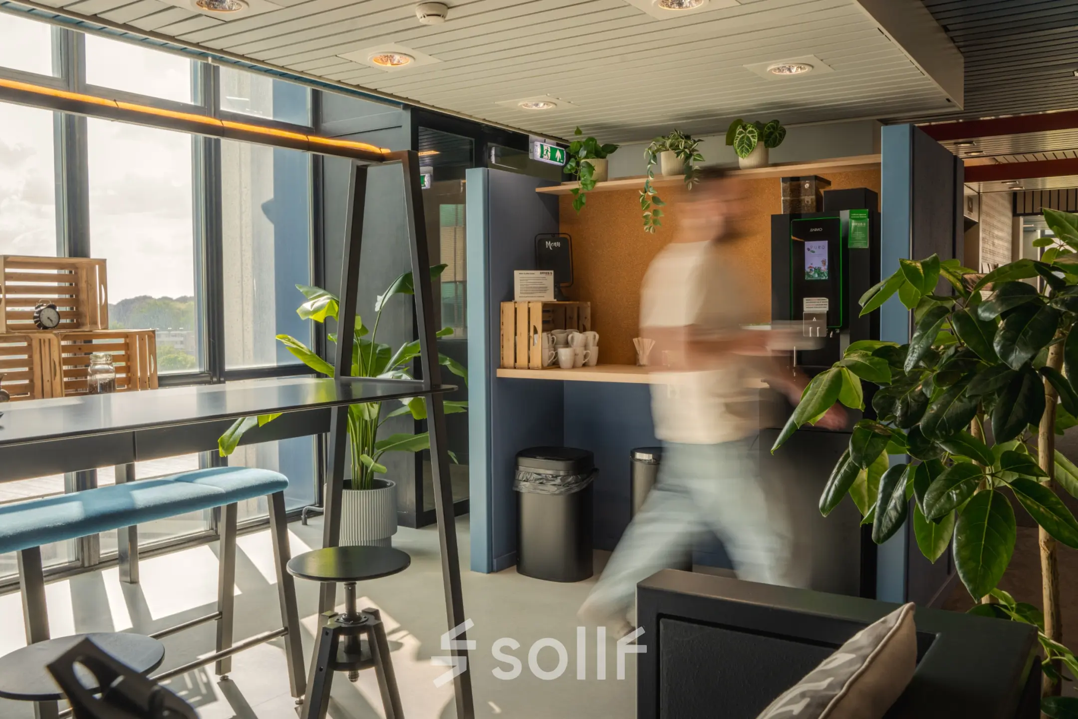 Lively office space to rent at Torenallee 20, Eindhoven Strijp-S featuring a modern furnished lounge with plants and seating area.